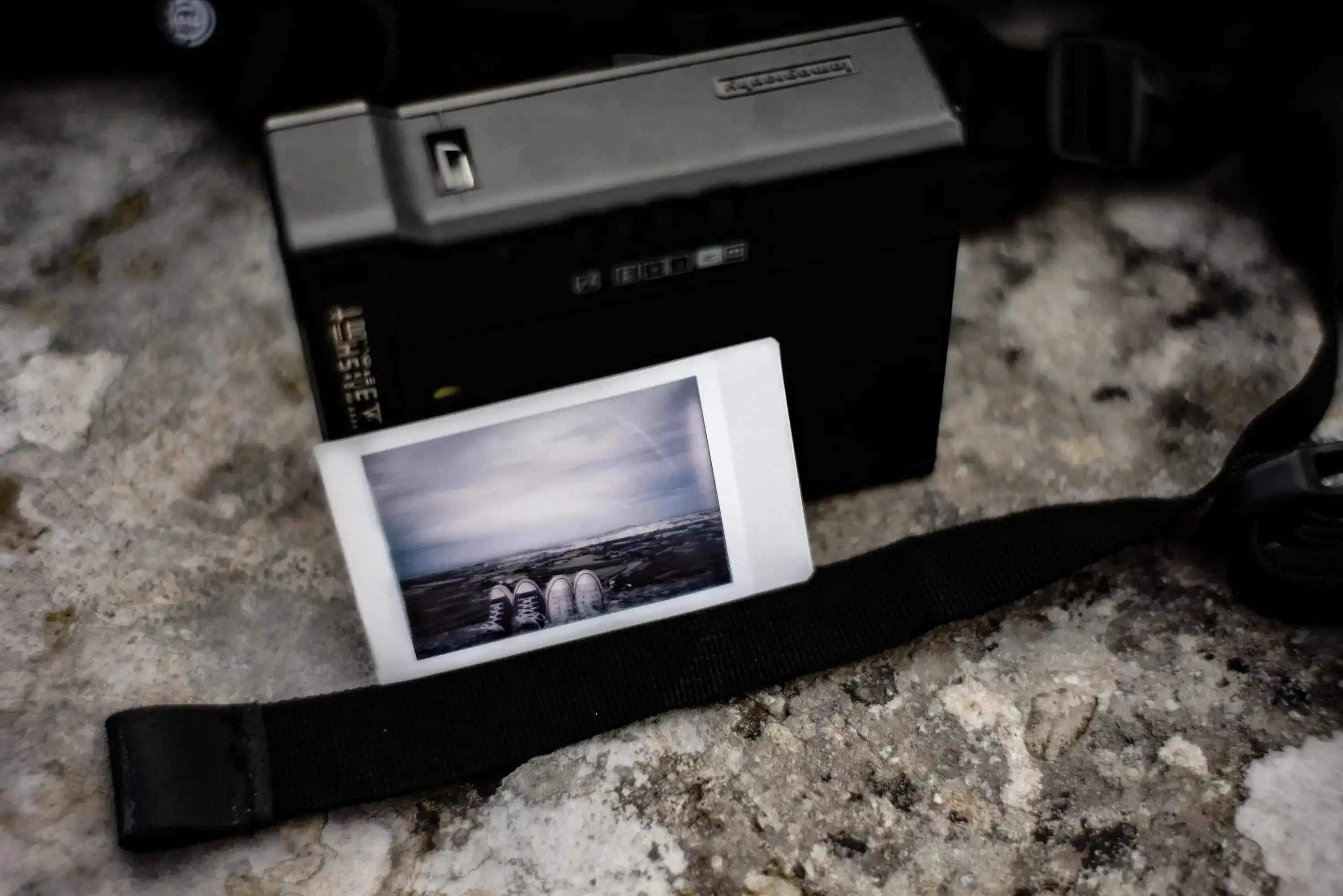 A physical Polaroid photo placed carefully on the ancient stone walls of Mdina.