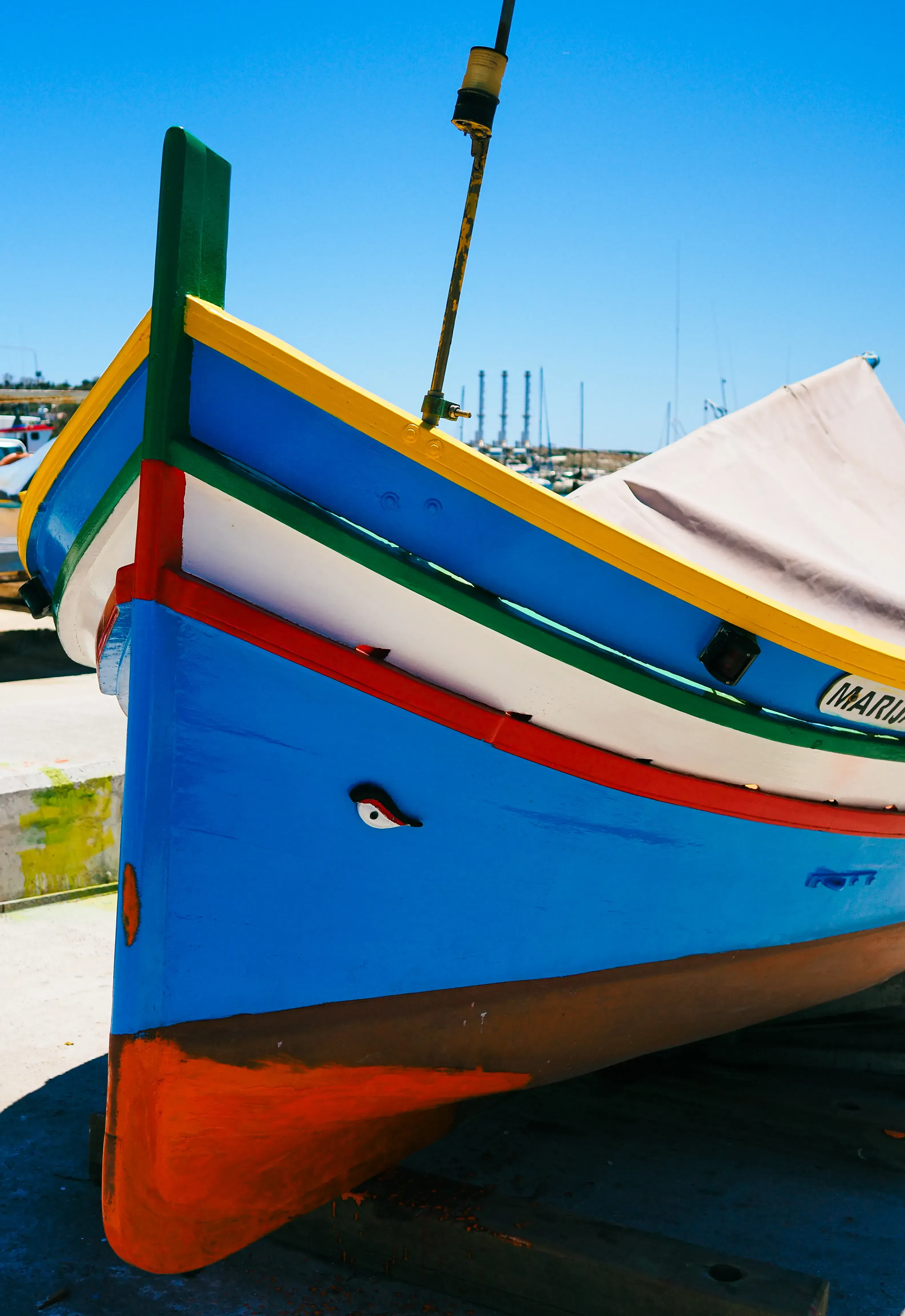Close-up detail of the painted bow (prow) and traditional eye symbol of a Luzzu boat.