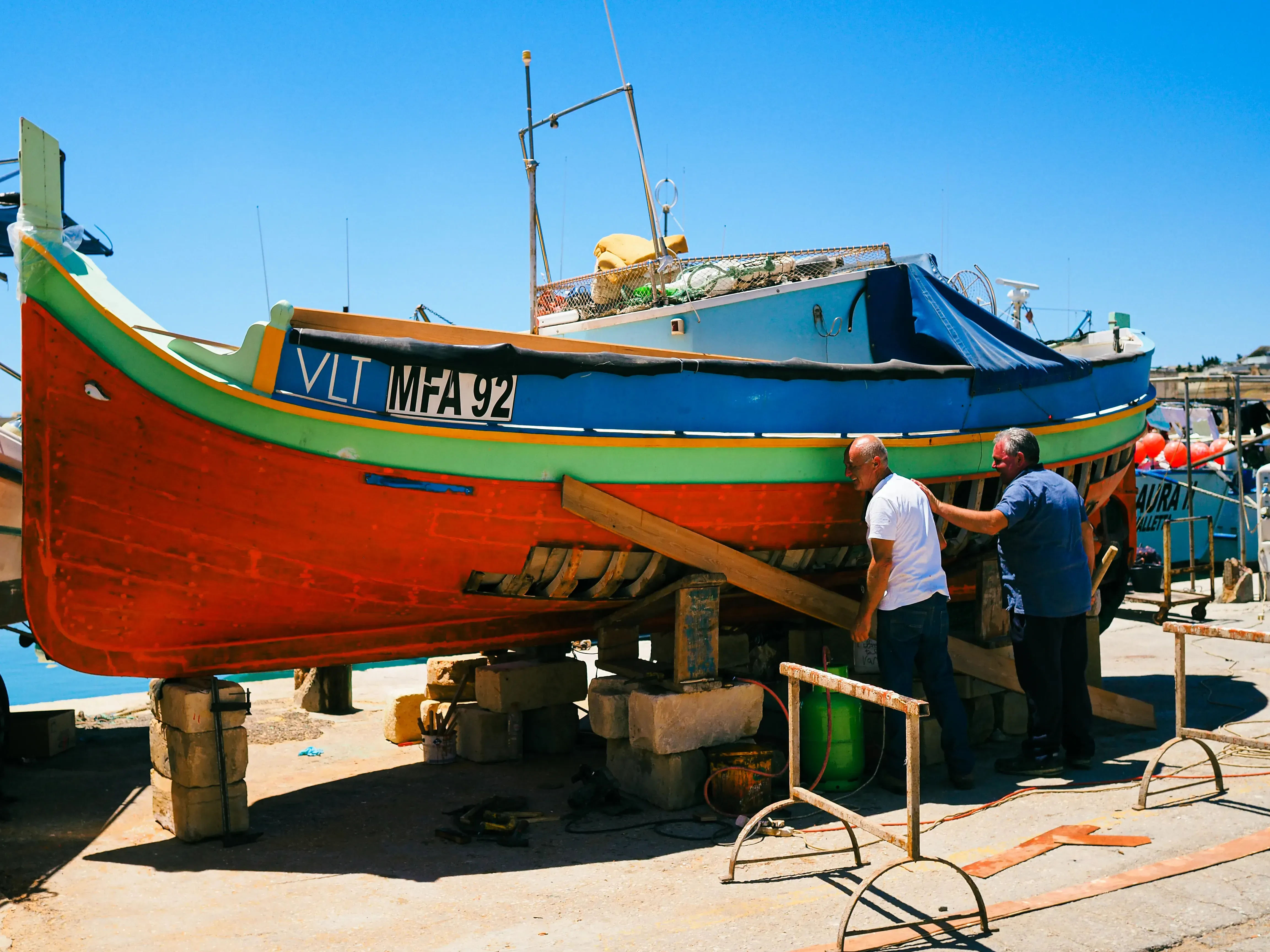 The iconic brightly painted Luzzu fishing boat docked in the Marsaxlokk harbor.