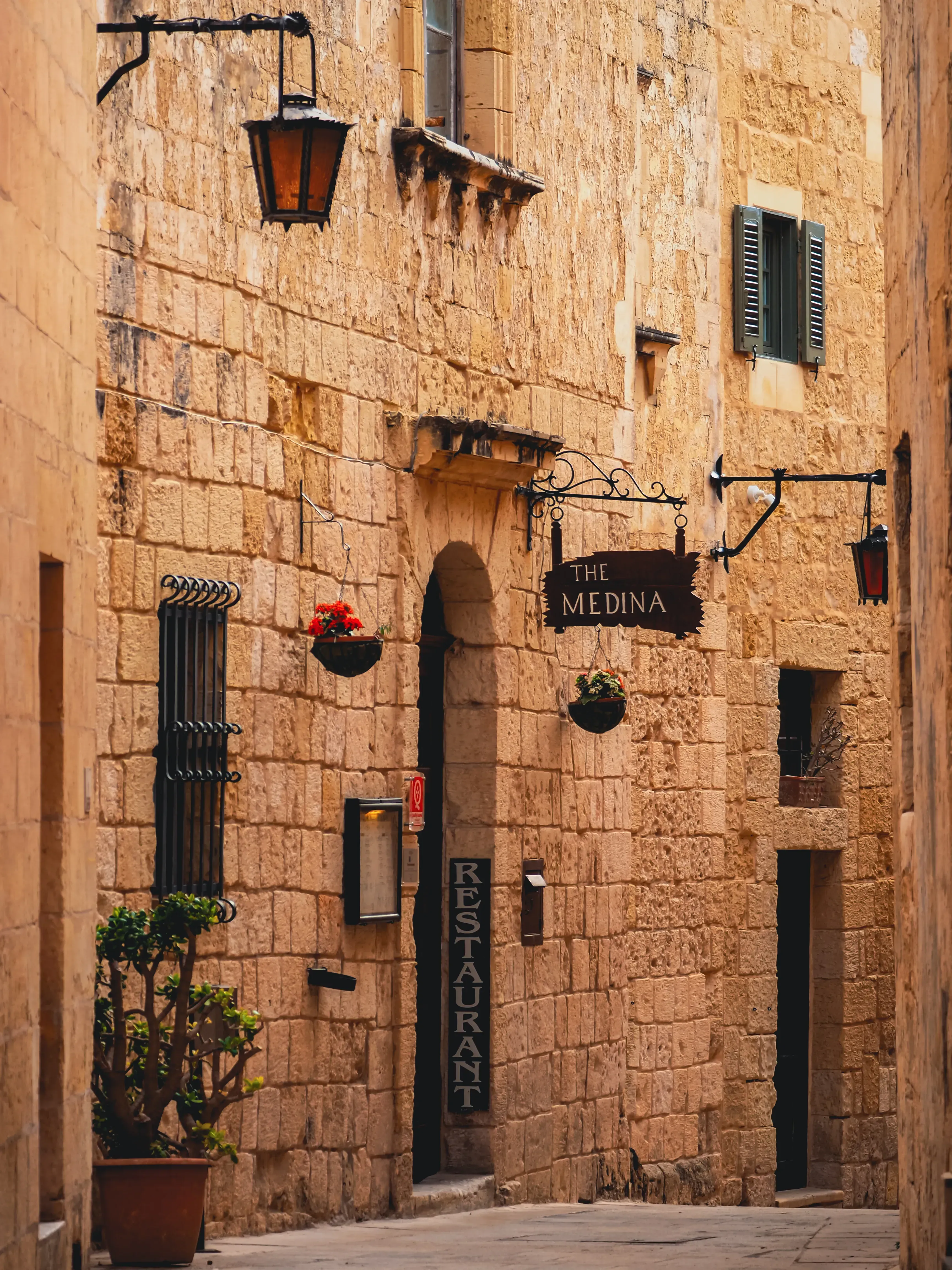 Stone wall of a restaurant located within the historic fortified city of Mdina.