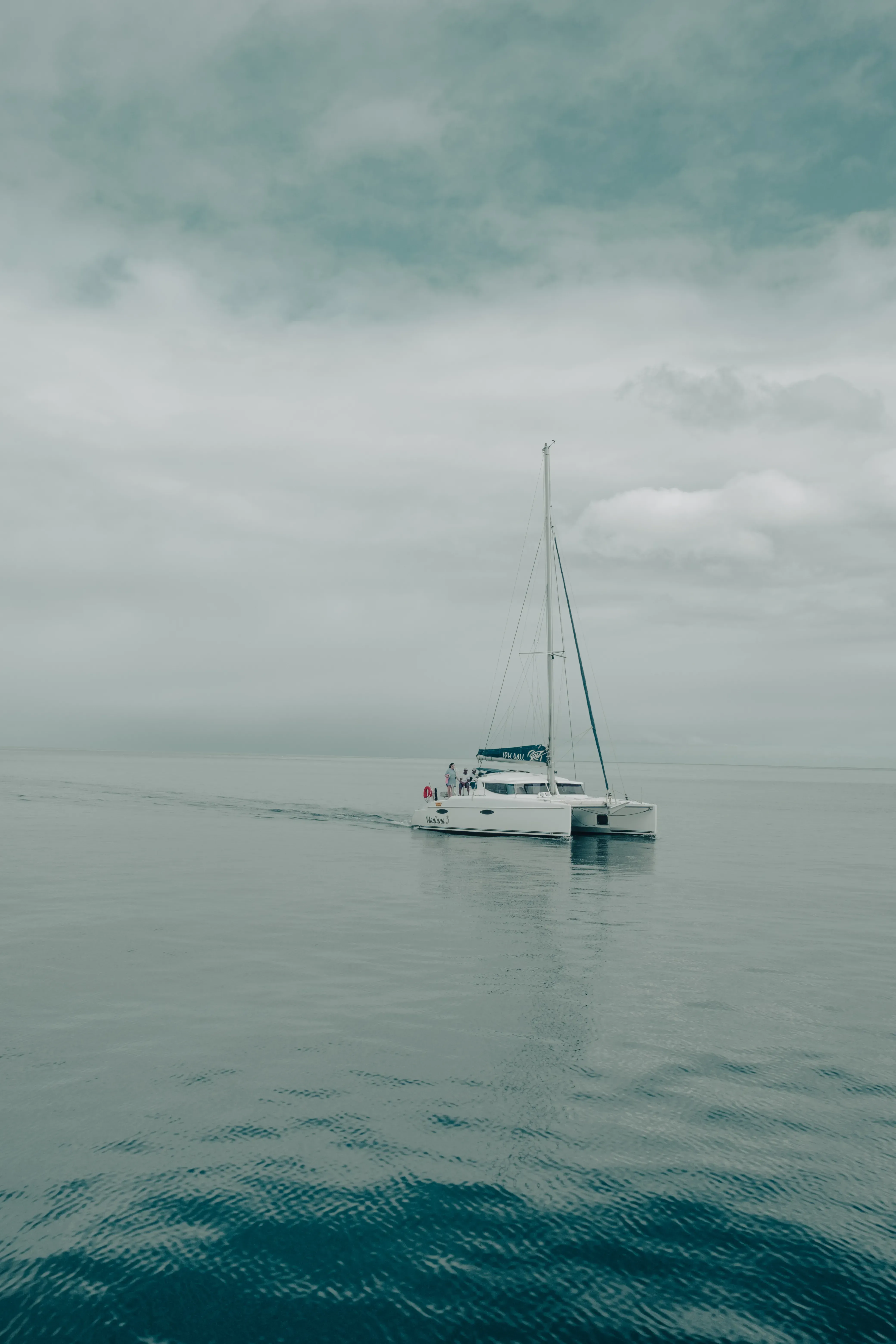 A large sailing catamaran floating on the open, calm waters just off the coast of Mauritius.
