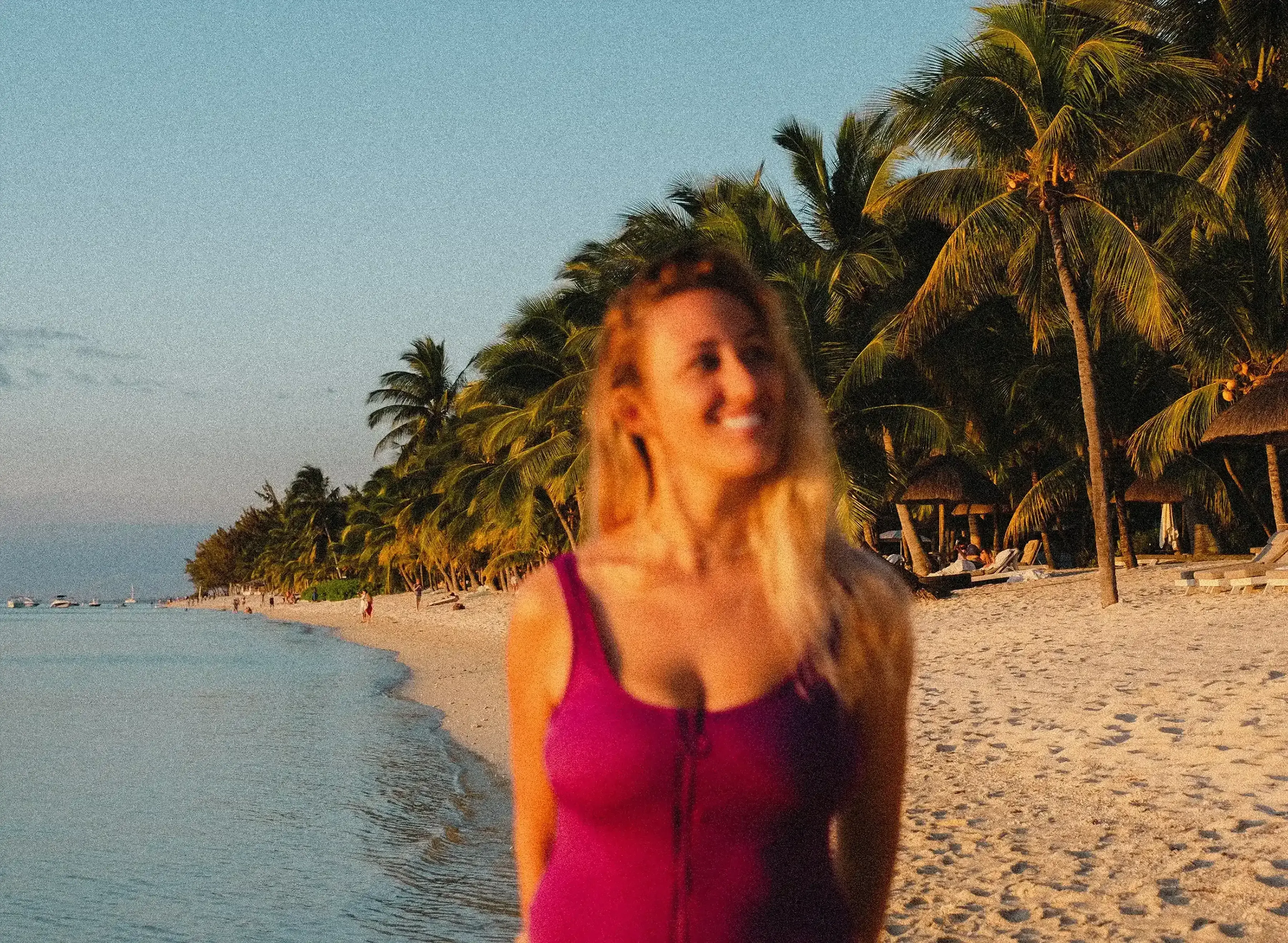 Letizia smiling brightly while posing on the pristine white sand of Le Morne beach.