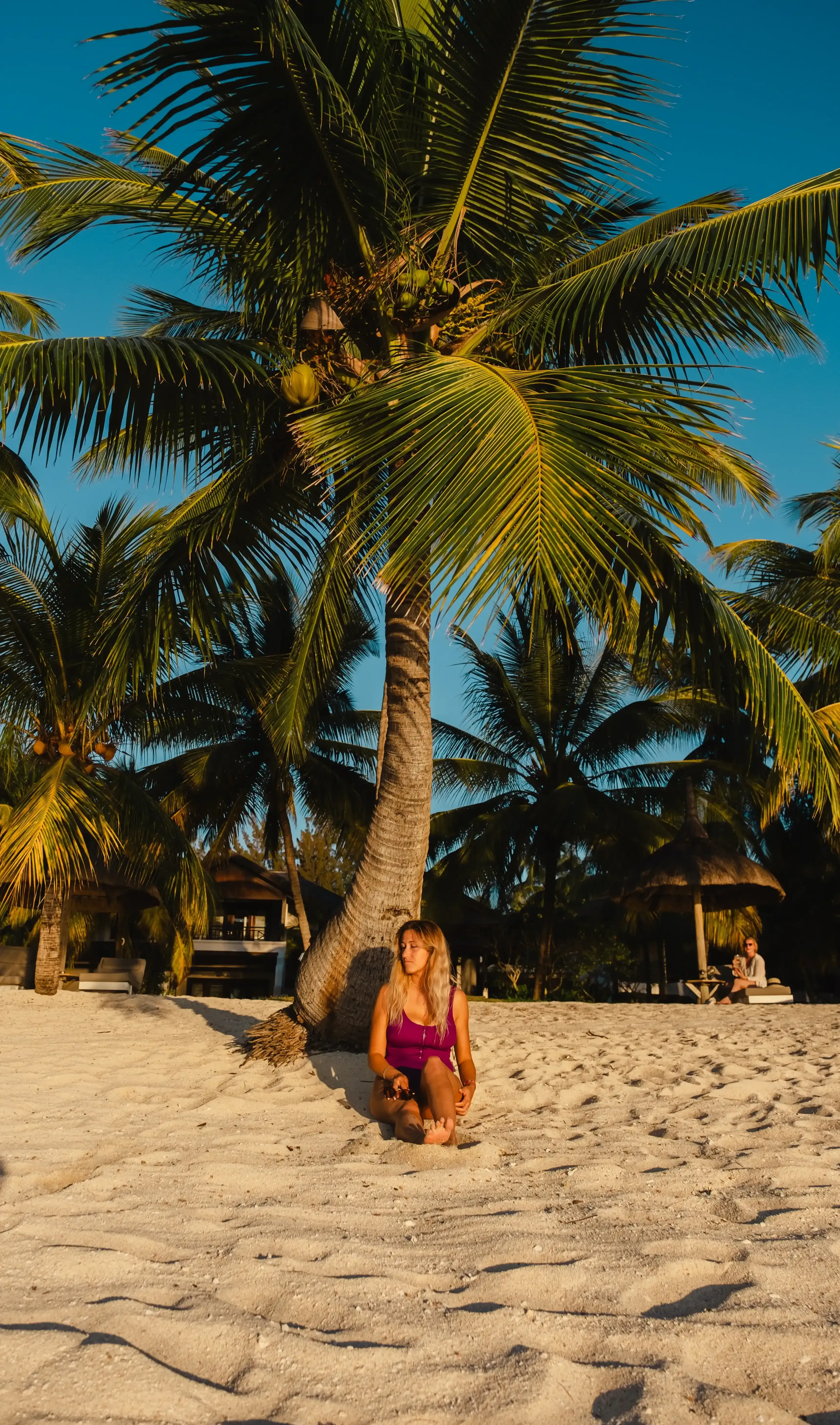 Letizia relaxing, lying down on the pristine white sand of Le Morne beach.