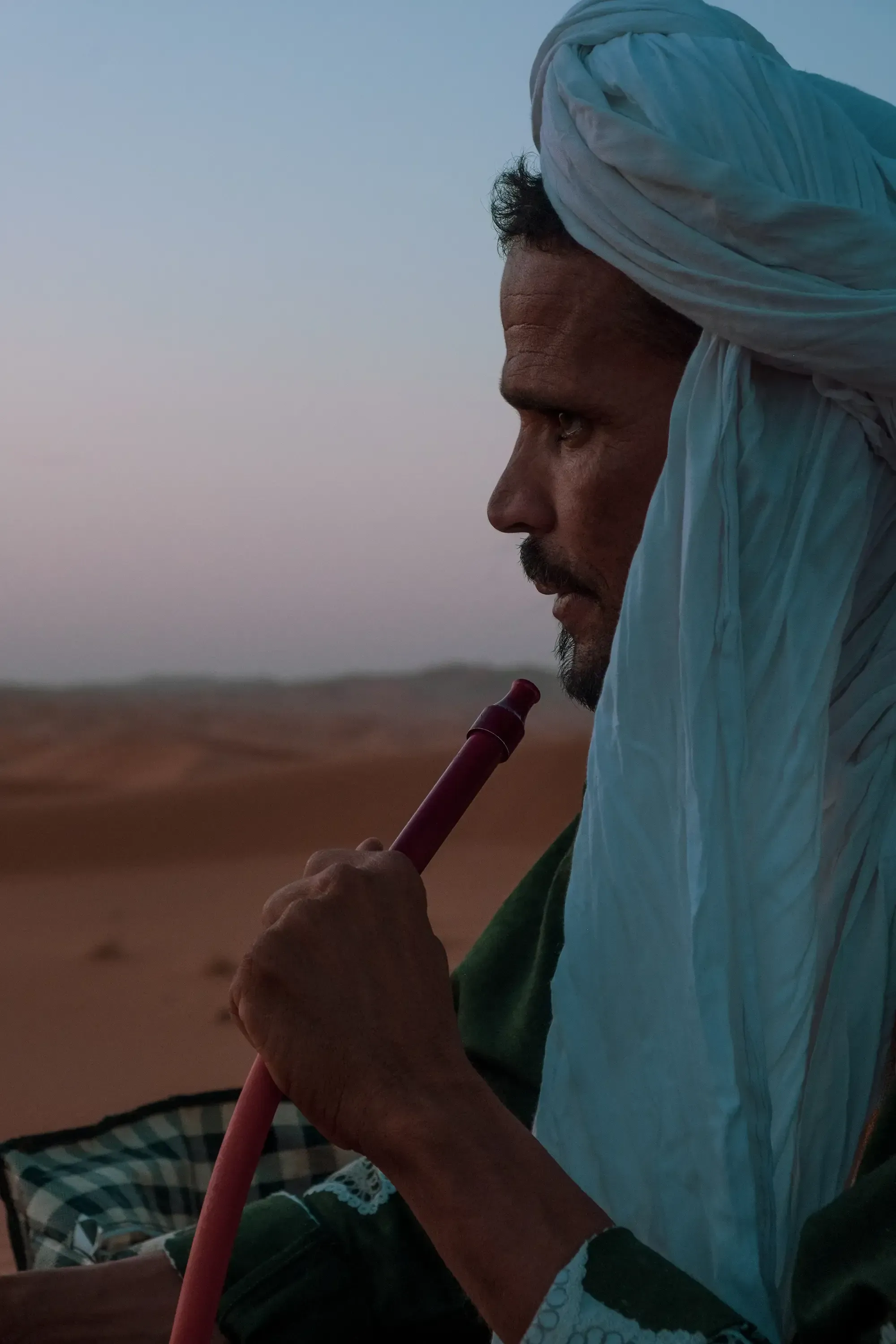 Desert guide or local man smoking a traditional hookah or shisha pipe (narghilè).