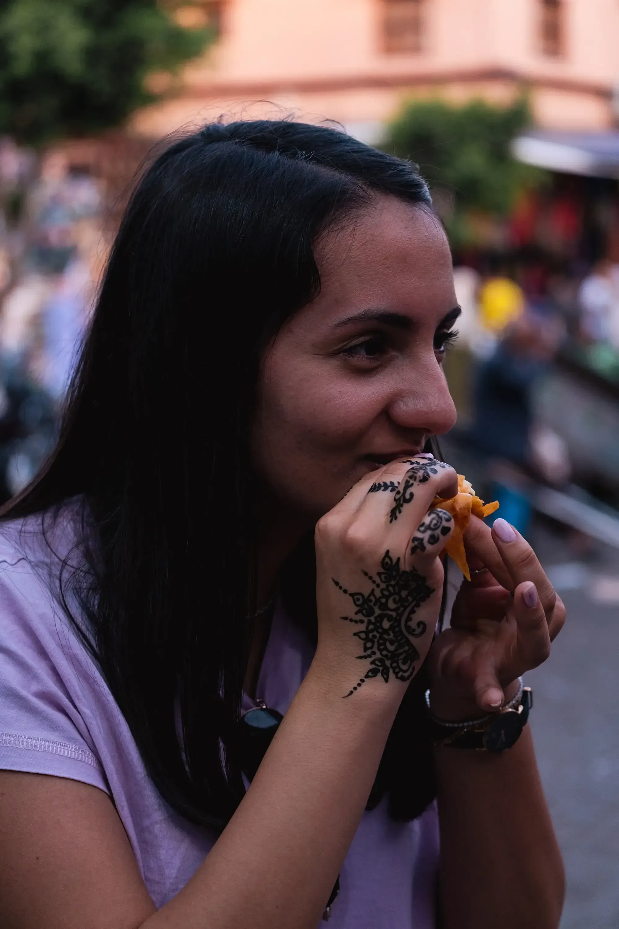 Feride tasting a piece of local or exotic fruit in the market.
