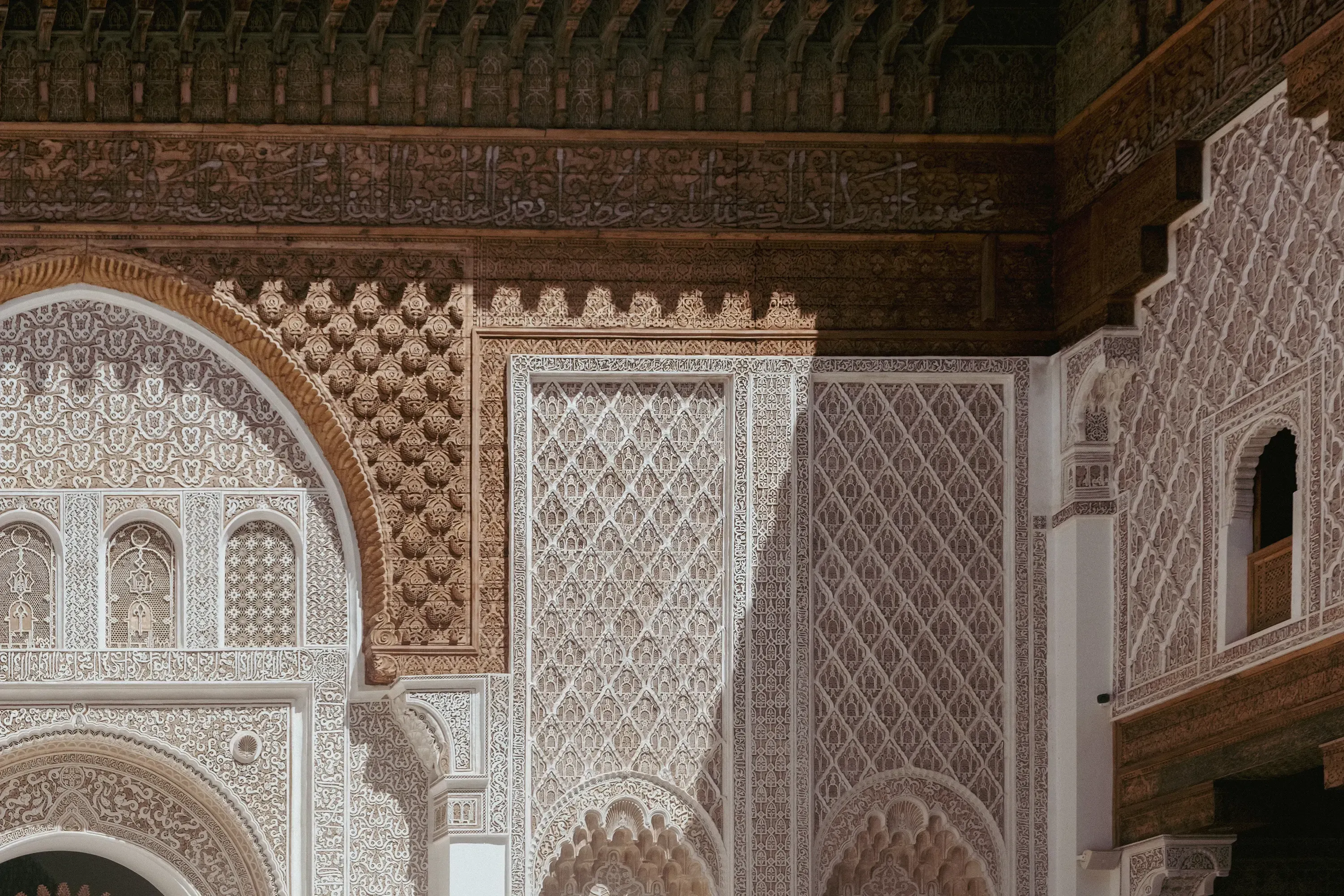 Detailed view of the geometric wooden roof and cedar ceilings inside the Ben Youssef Madrasa.