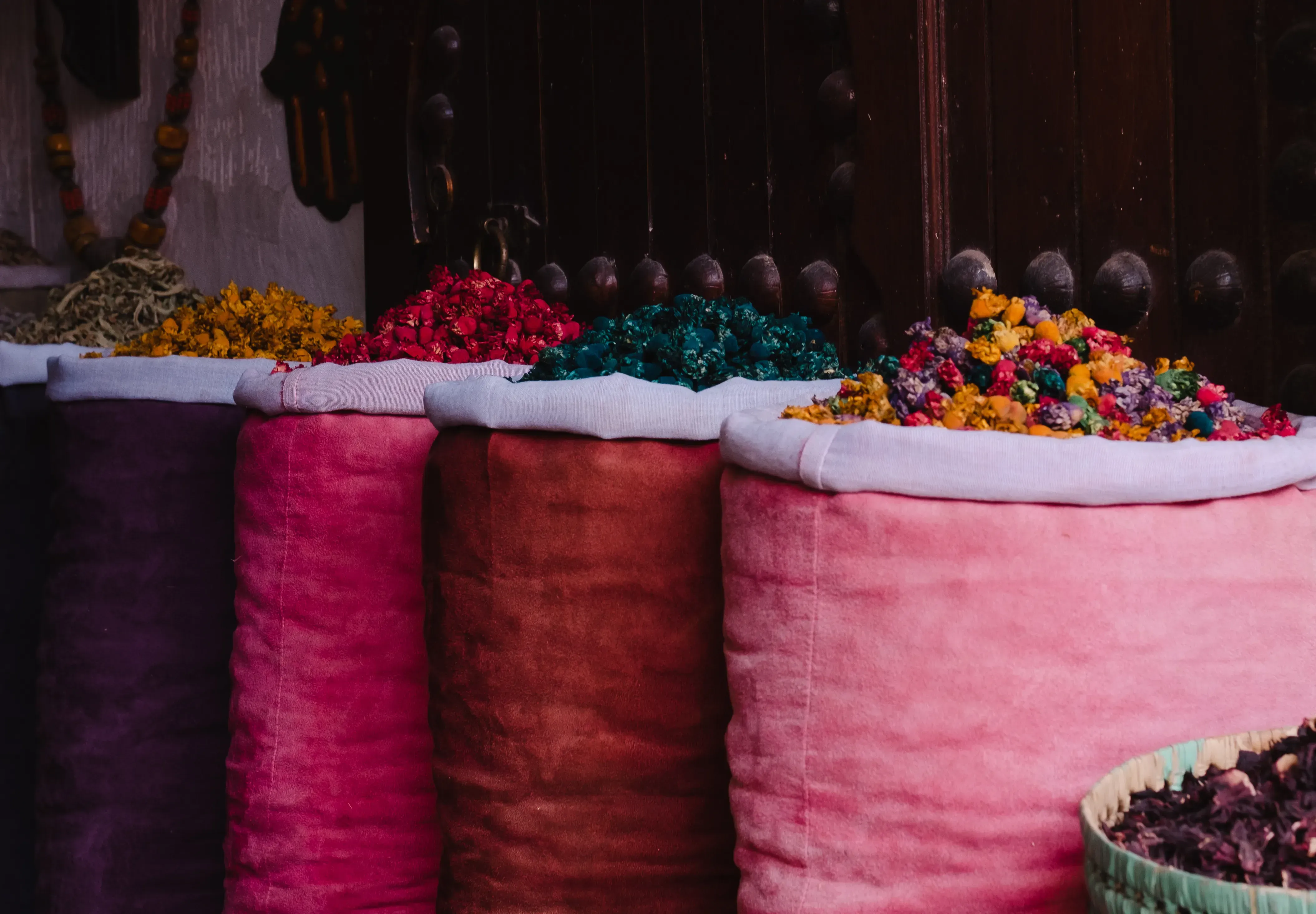 Colorful array of ground spices displayed in large jute sacks in a market.