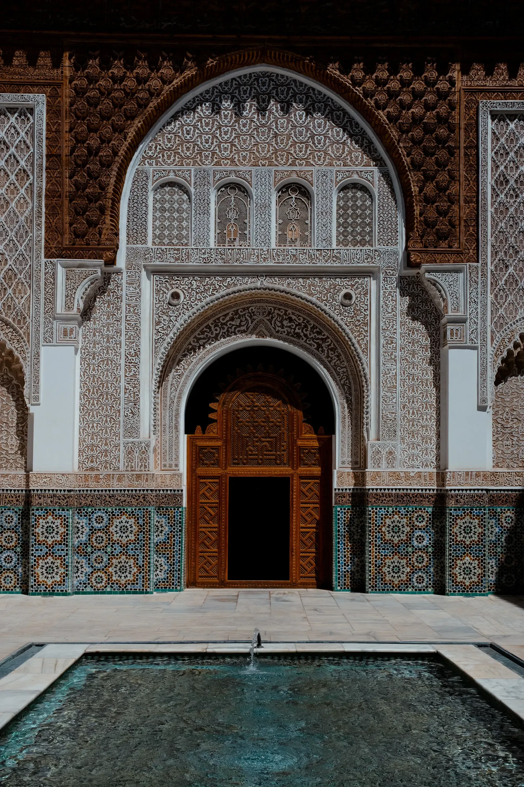 Ornate wooden doorway entrance of the historic Ben Youssef Madrasa in Marrakech.