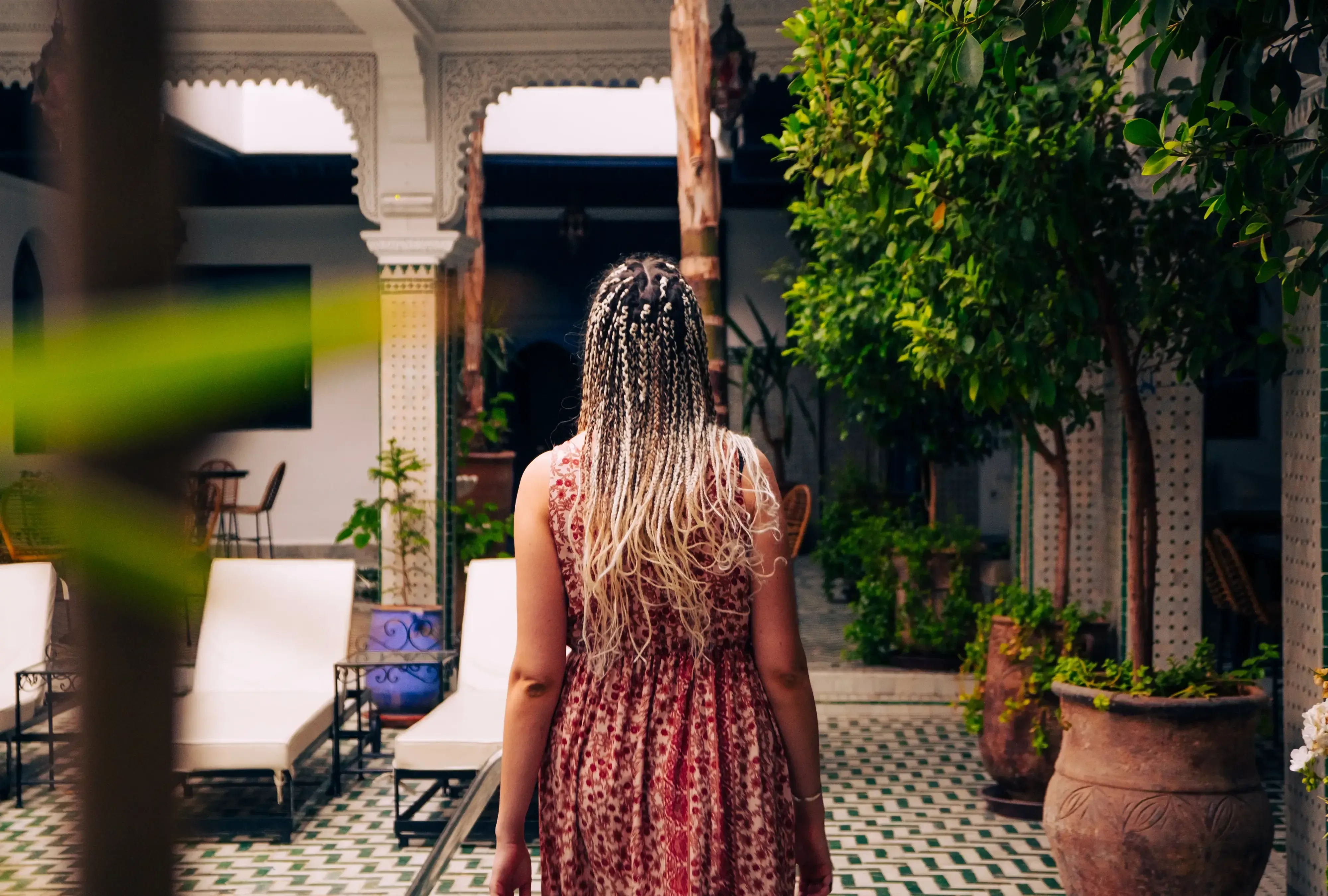 Letizia walking through the intricately tiled patio of a Moroccan Riad.