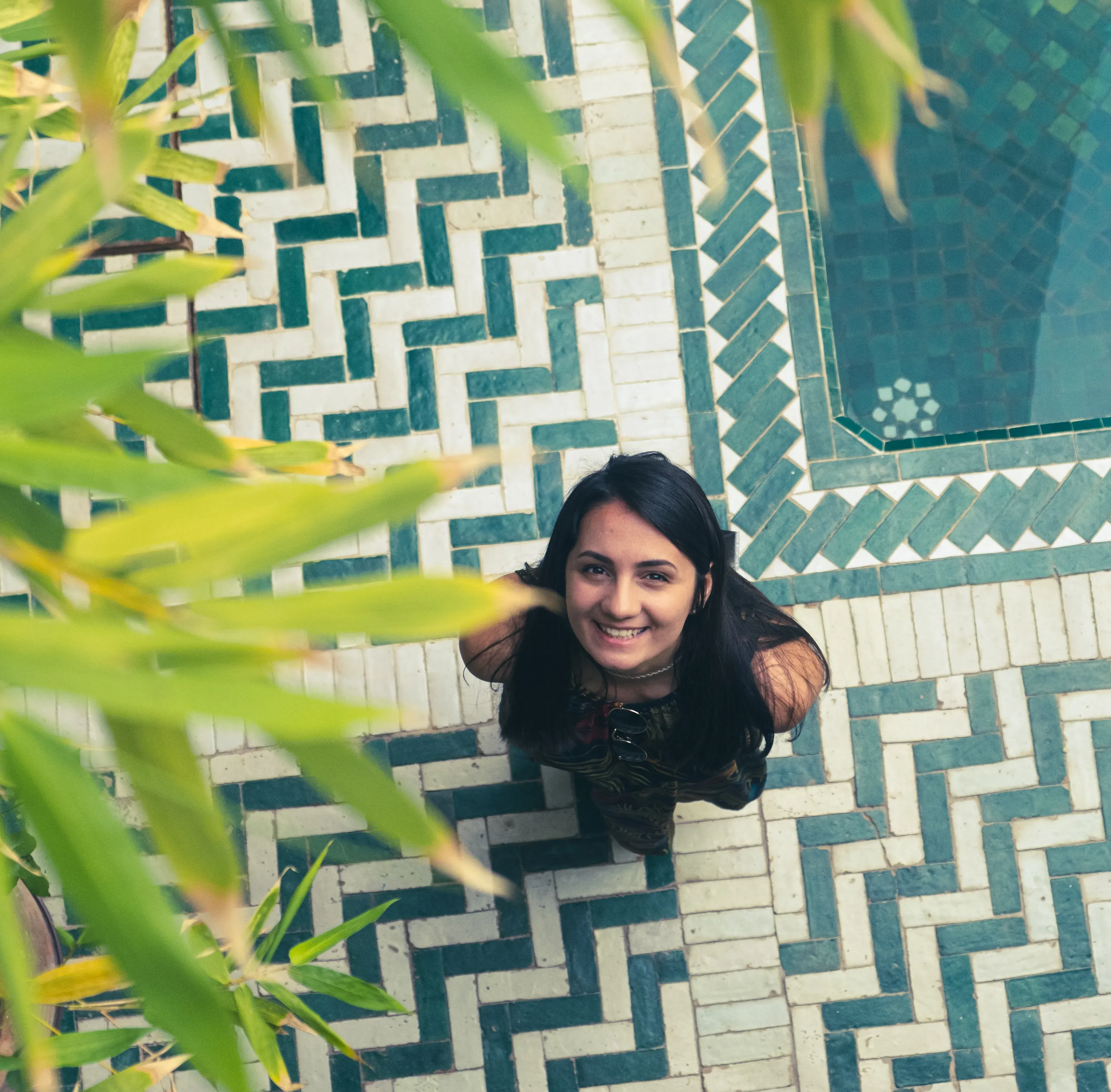 Feride smiling while seated inside the central courtyard of a traditional Riad.