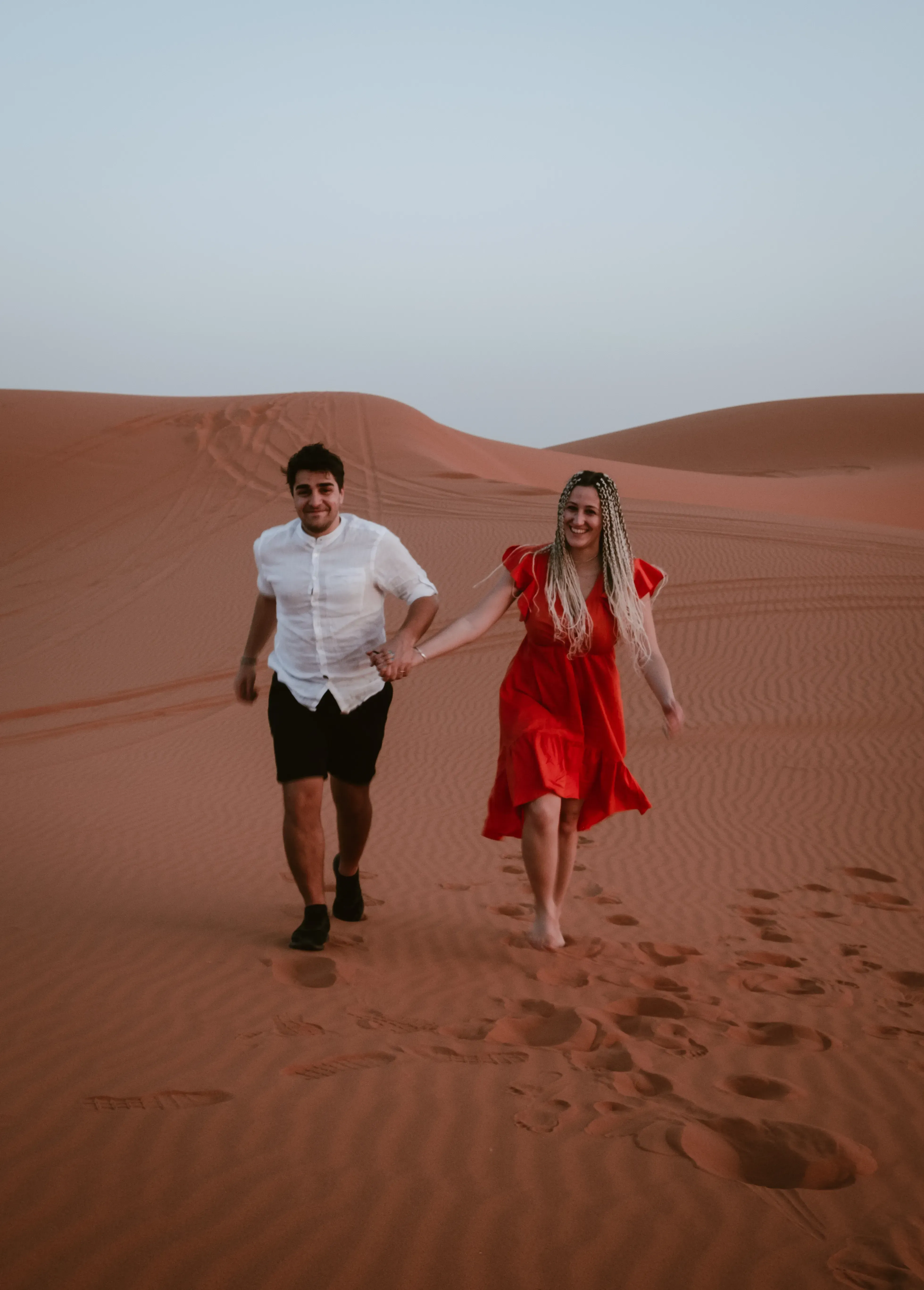 Ieser nd Letizia running hand-in-hand across the desert sand.