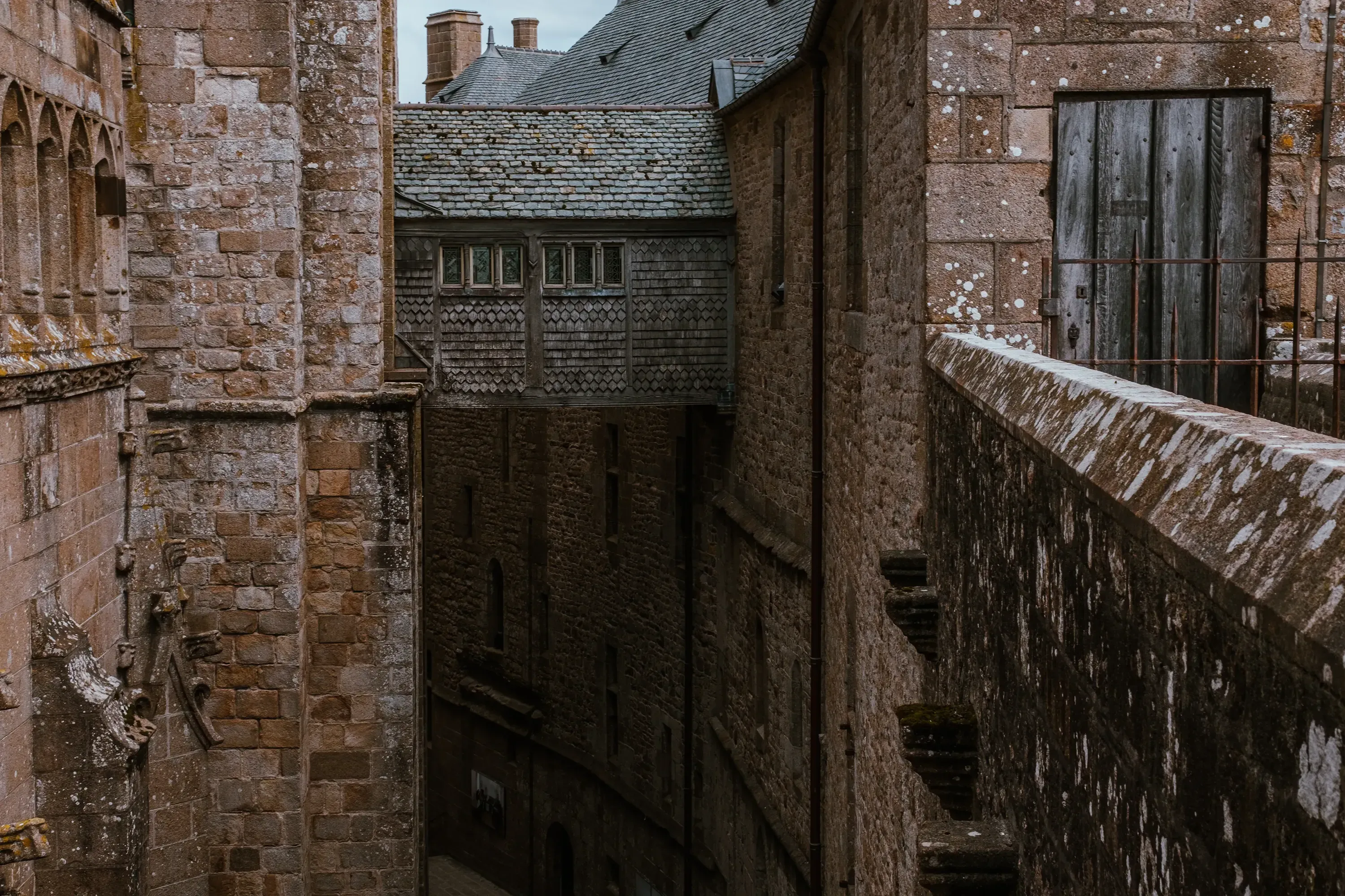 The exterior view of a high, covered walkway or gallery within the Abbey complex.