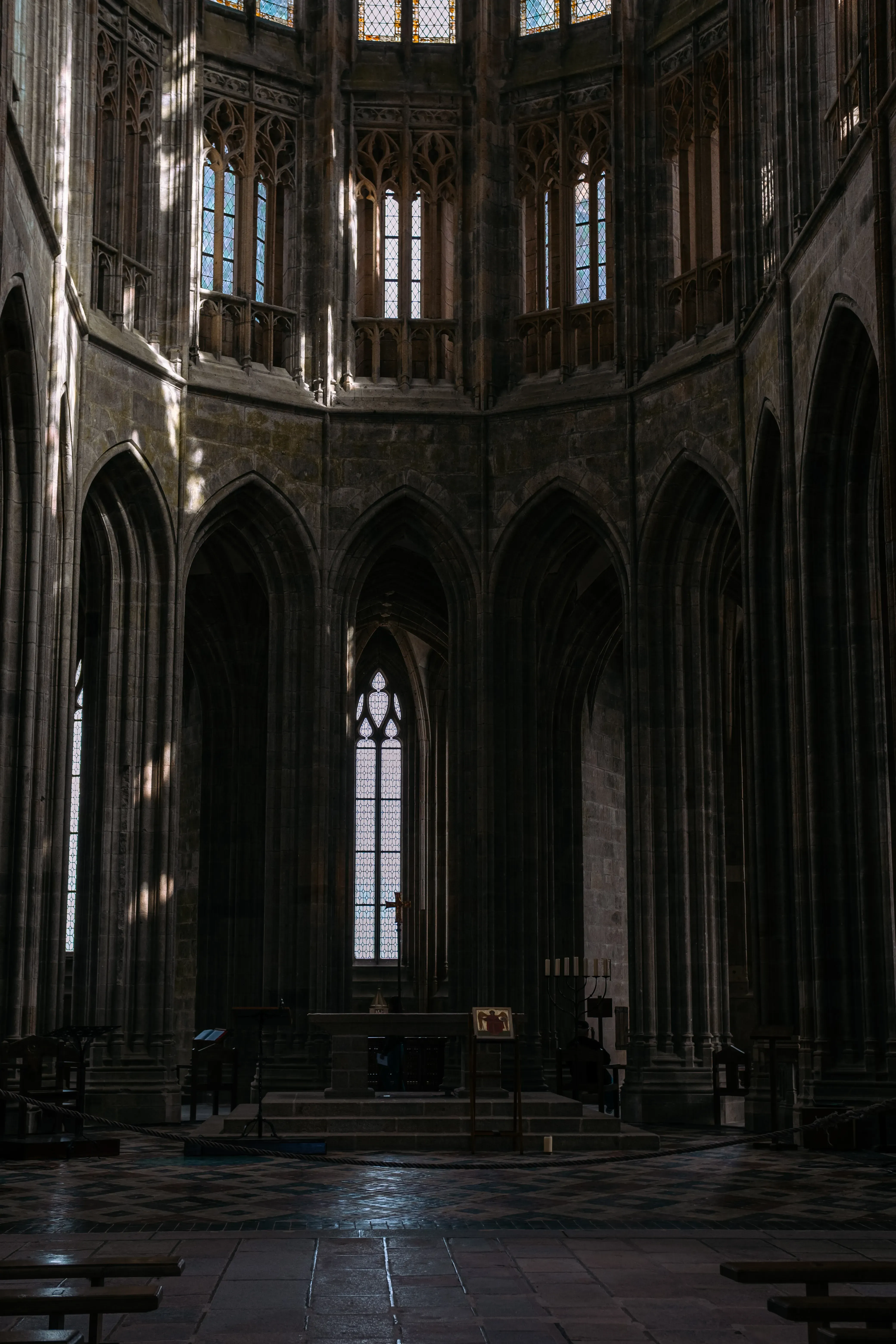 An interior view looking up at the high vaulted ceiling and upper architecture of Mont Saint-Michel Abbey Church.