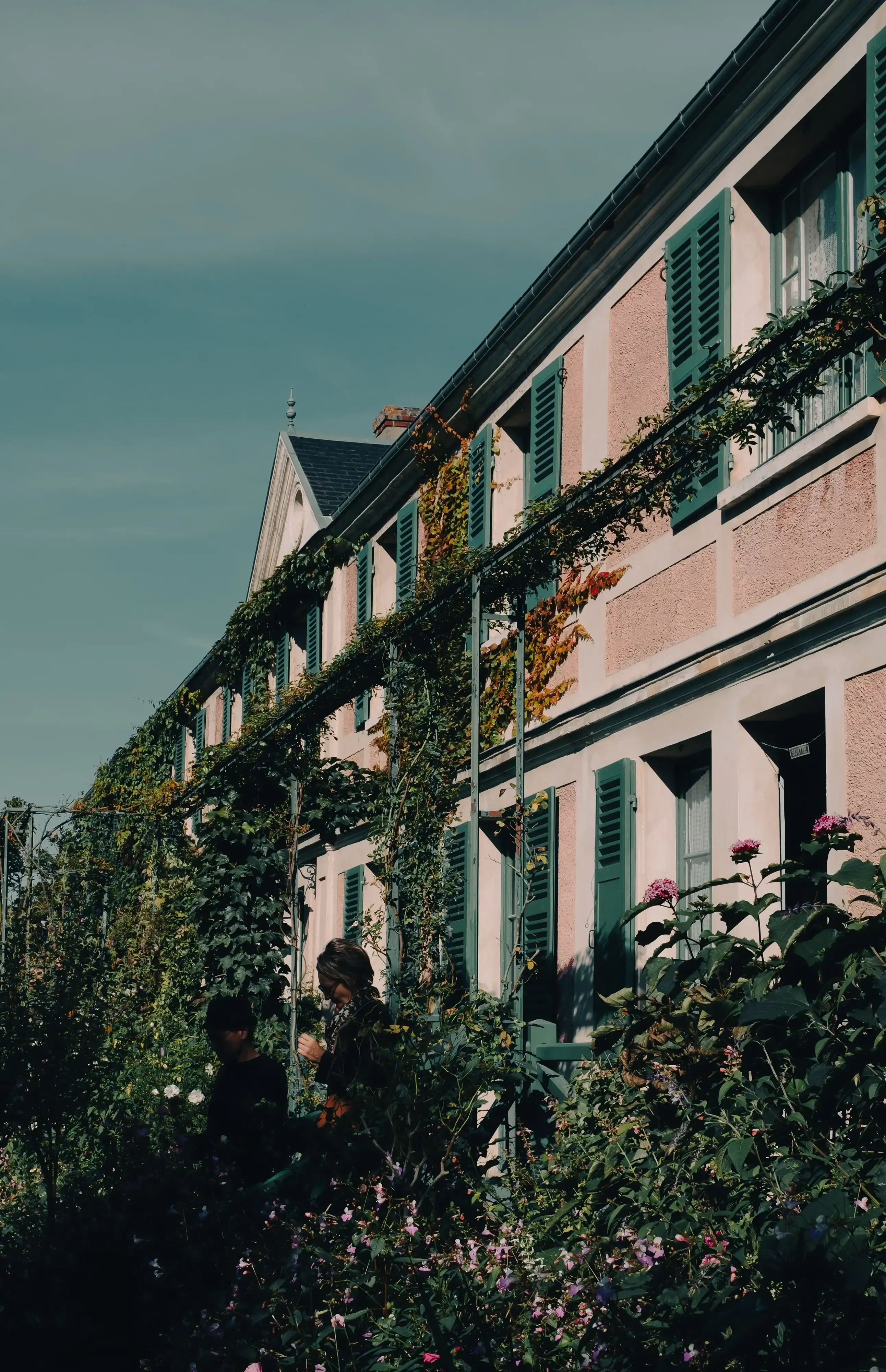 The exterior view of Claude Monet's pink house with green shutters at Giverny.