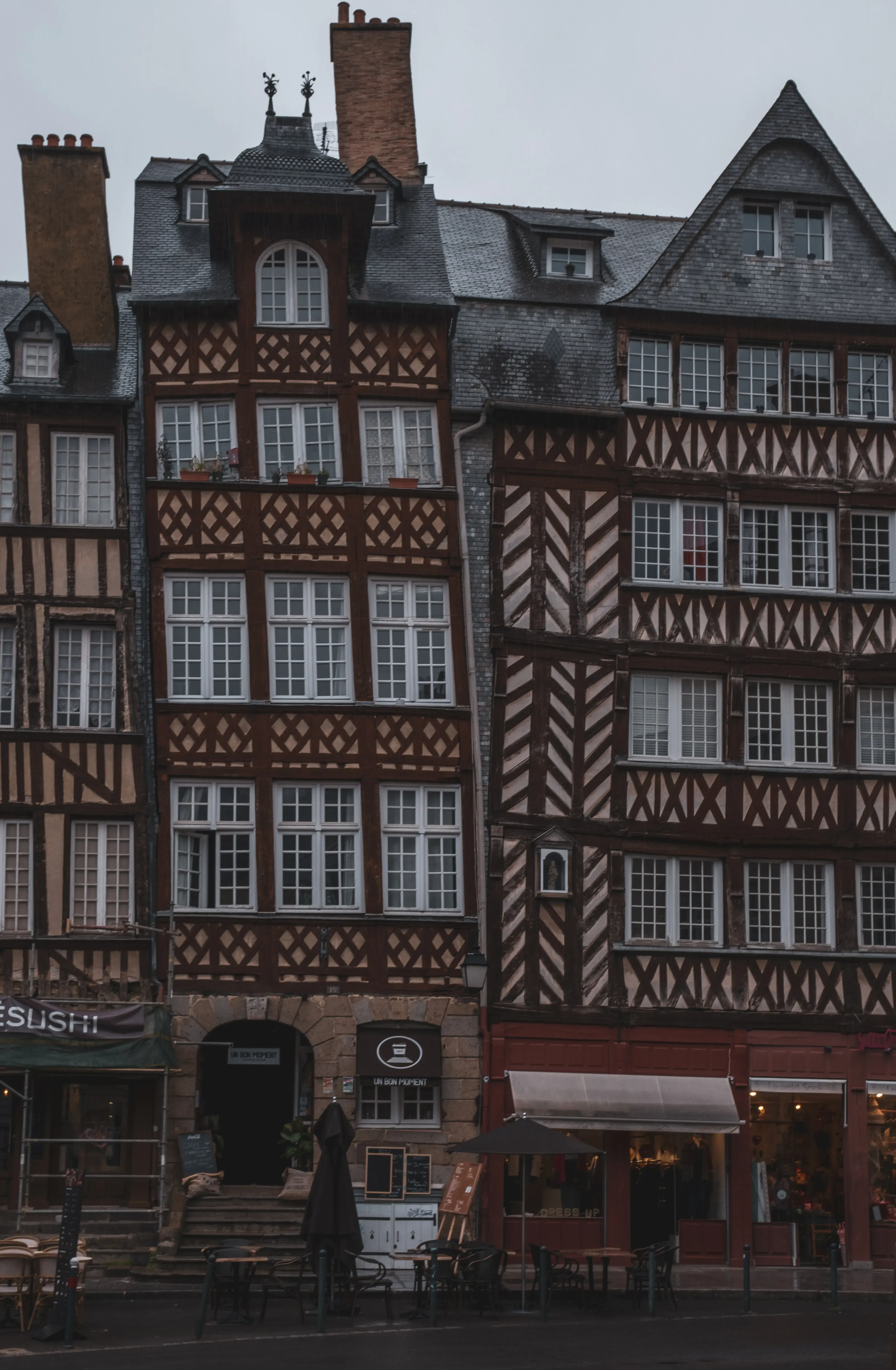 A close-up architectural detail of the facades of two adjacent, narrow houses in Honfleur.
