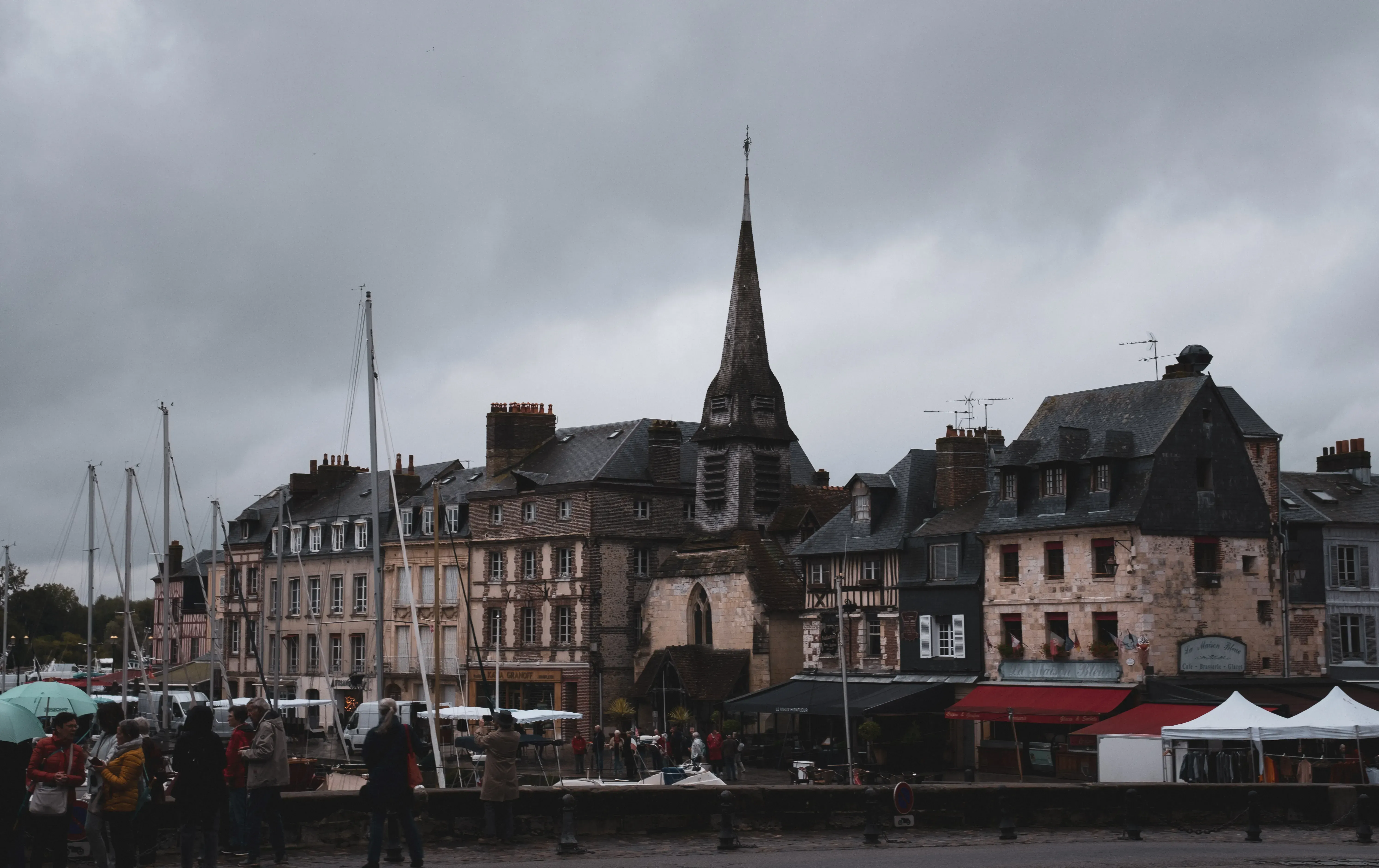 A wide view of the picturesque Vieux Bassin (Old Harbor) of Honfleur with boats docked.