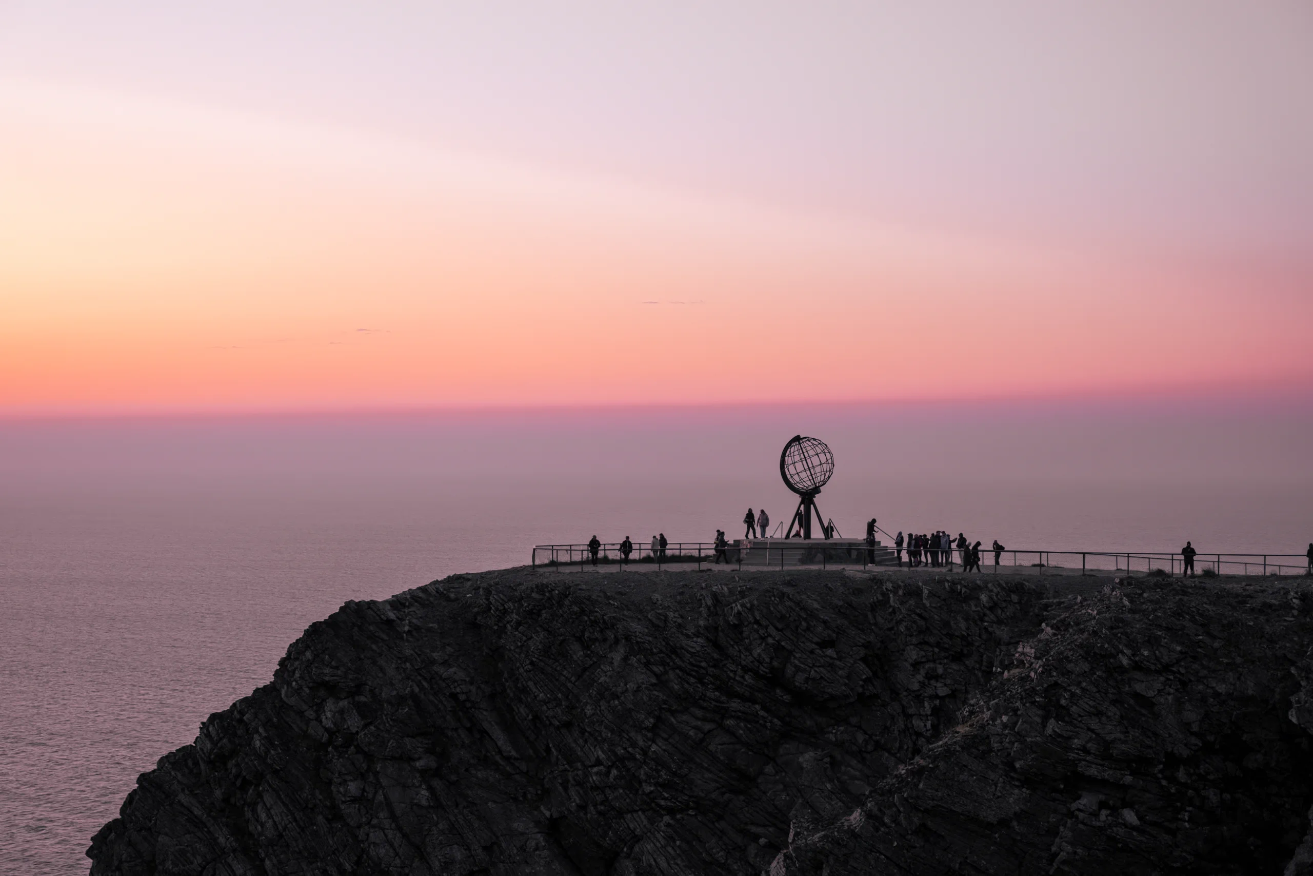 The iconic North Cape globe monument seen from a distance on the barren plateau.