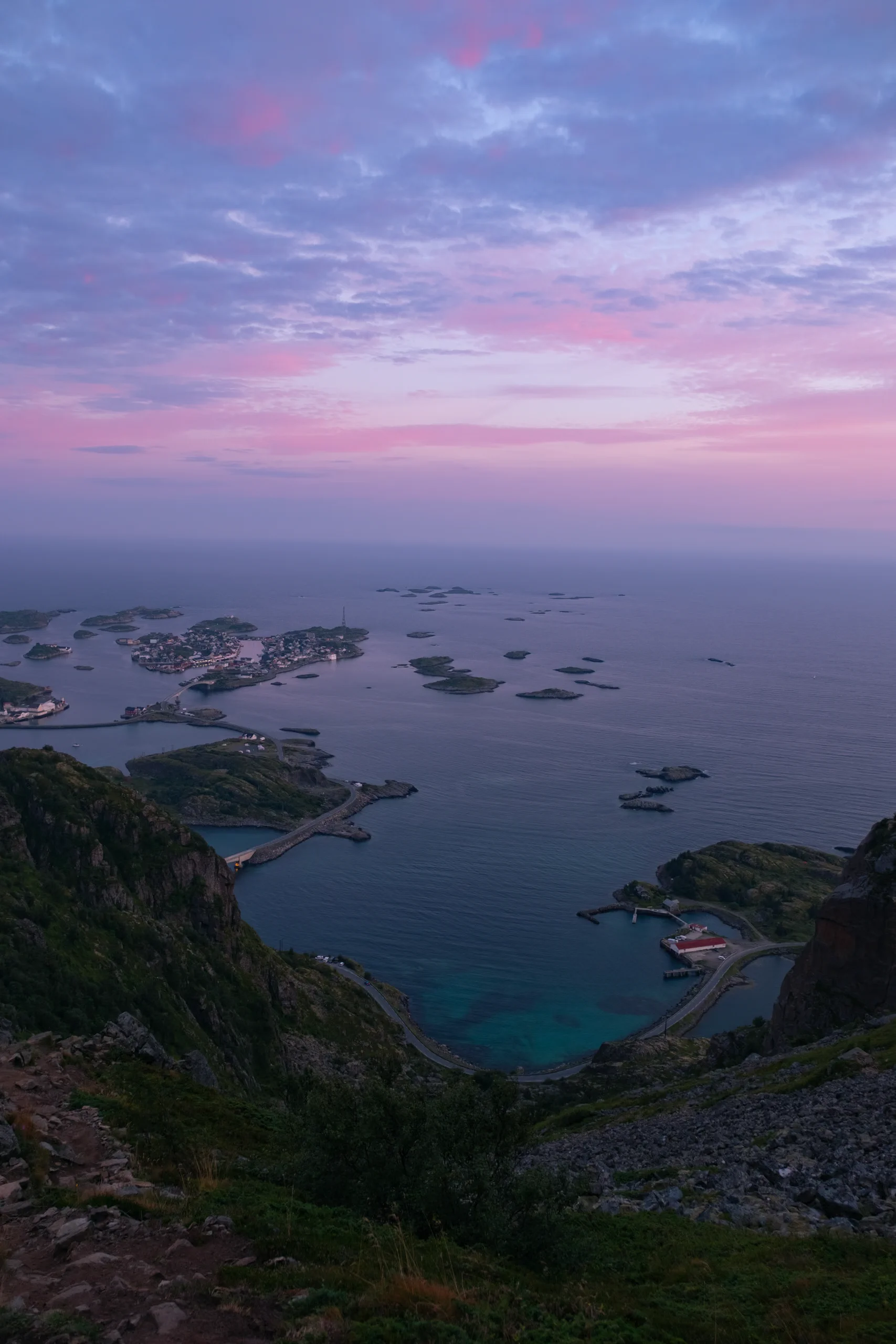 Sweeping landscape of the Lofoten islands bathed in the soft, pink light of sunset.
