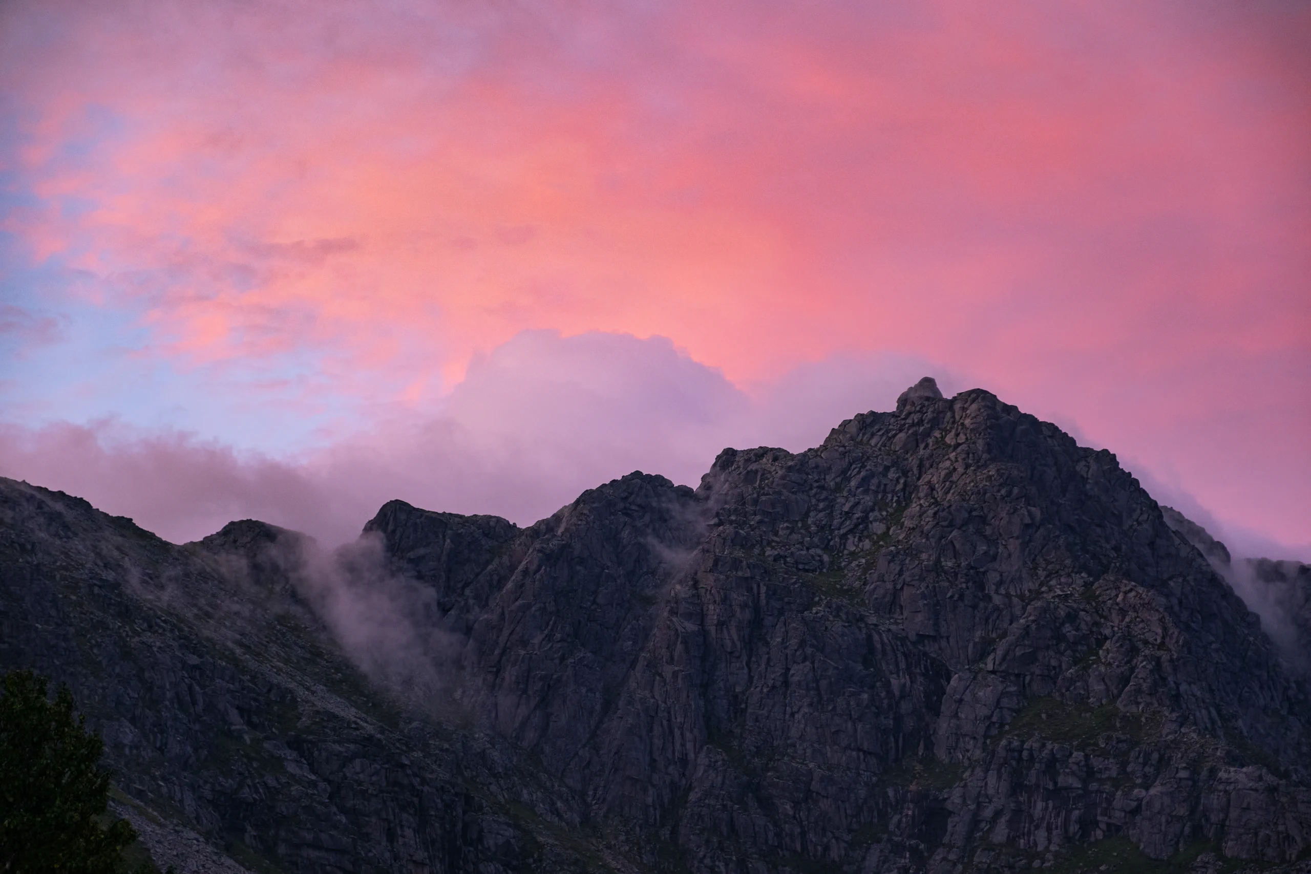 Lofoten mountain peaks silhouetted against a dramatic pink and purple sunset sky.