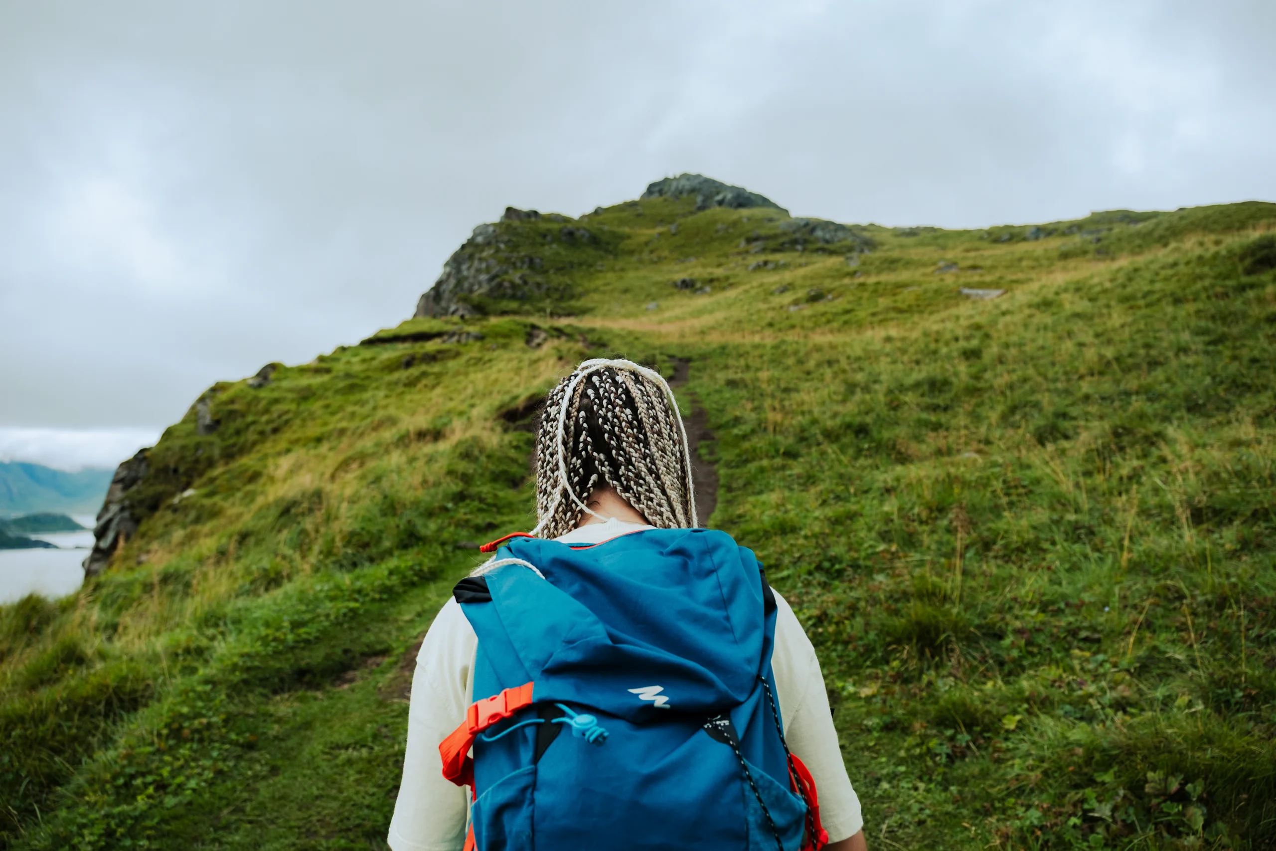 Letizia viewed from behind, hiking up the mountain path towards the summit.