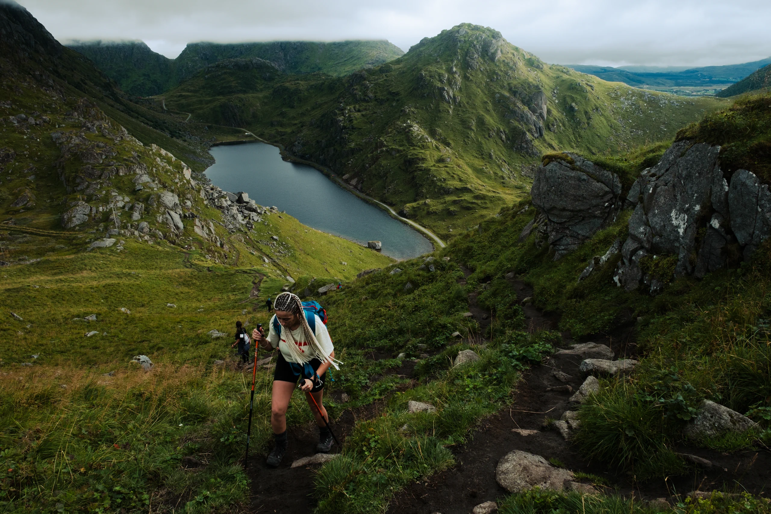 Letizia hiking up a steep path toward a scenic viewpoint in the Lofoten Islands.