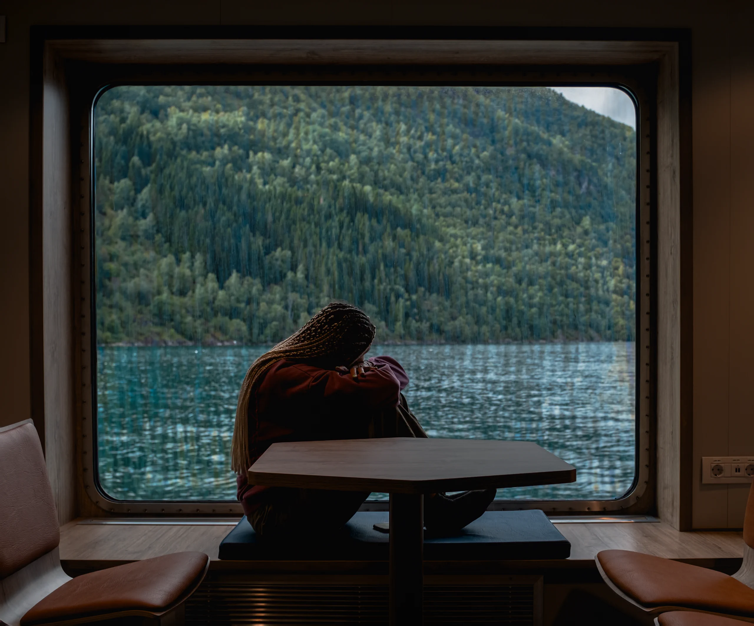 Letizia looking out the ferry window as it cruises through the Norwegian fjords,