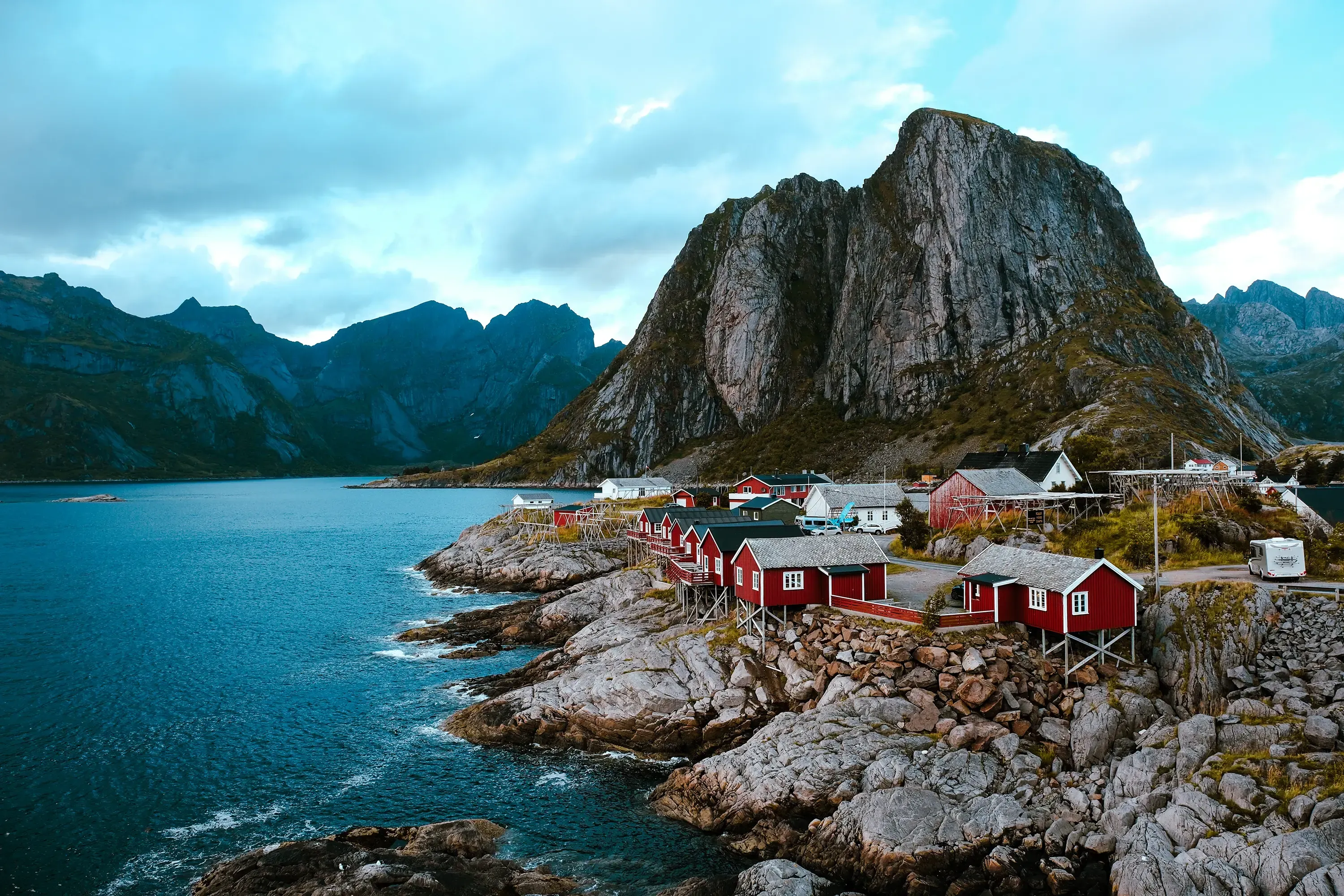 Iconic red fishing cabins (rorbuer) perched on the water's edge in the Lofoten Islands, Norway.