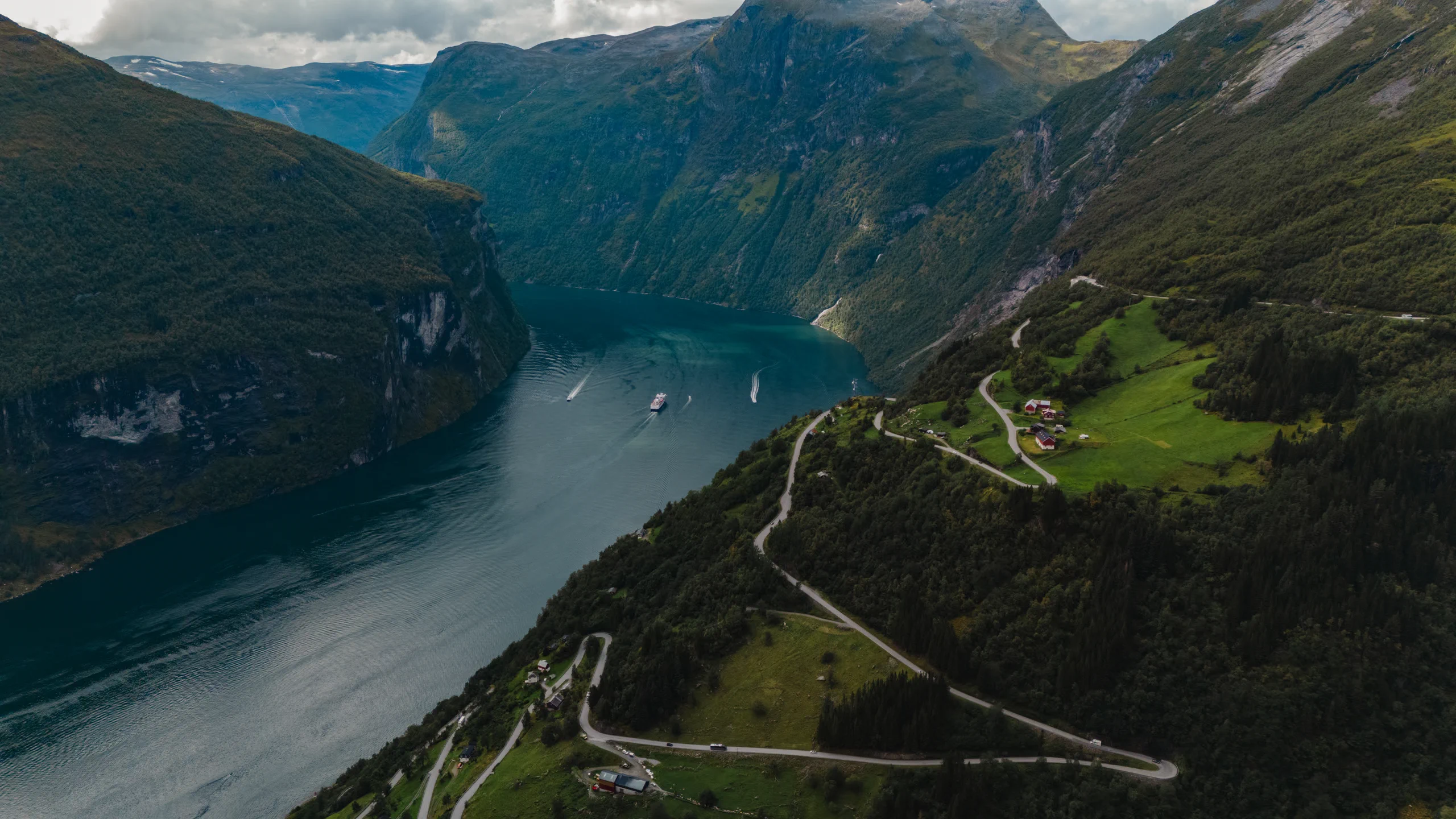 Winding mountain road (serpentine) running alongside a deep Norwegian fjord.