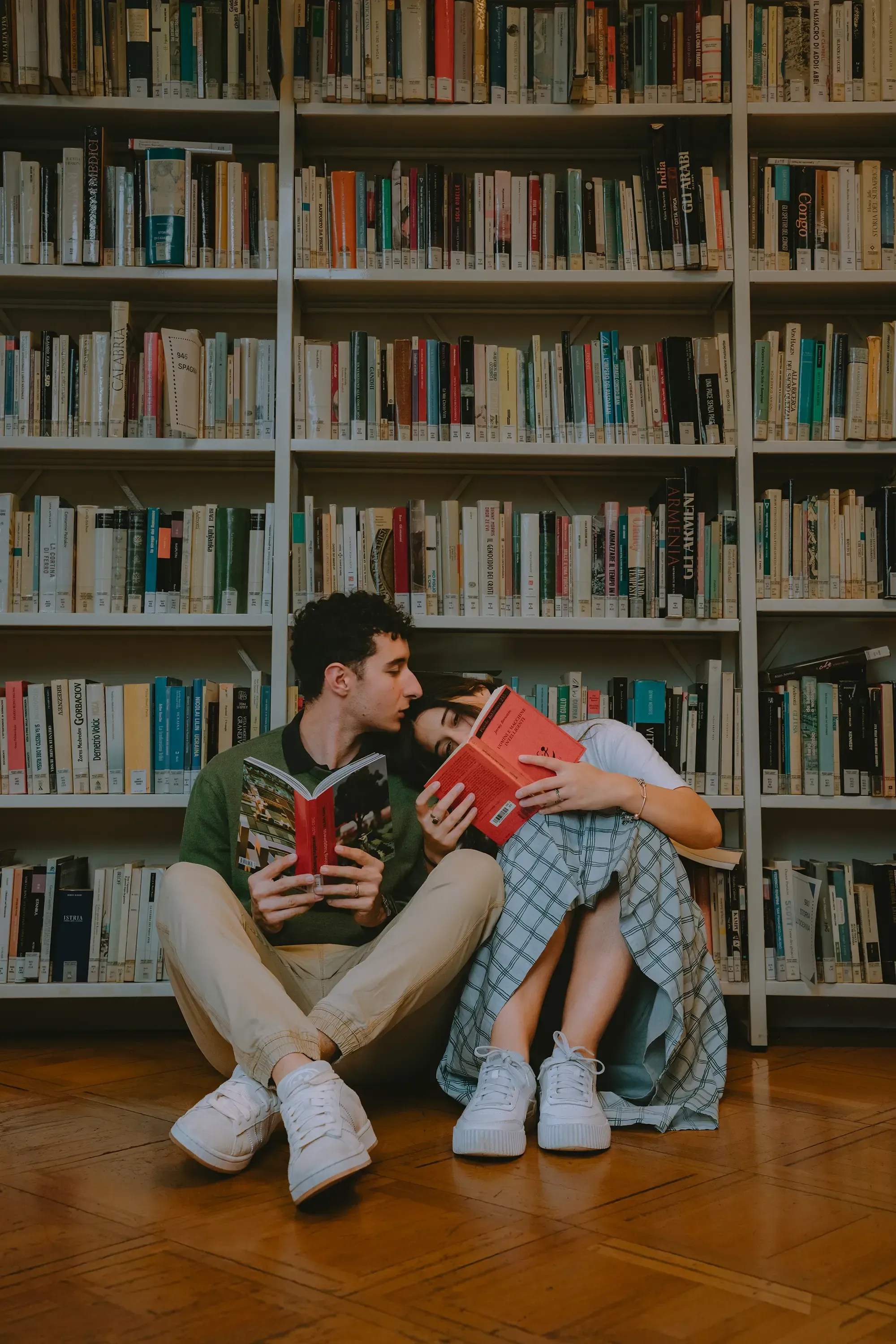 Paolo kissing Paulina on the head as she reads a book while sitting together.