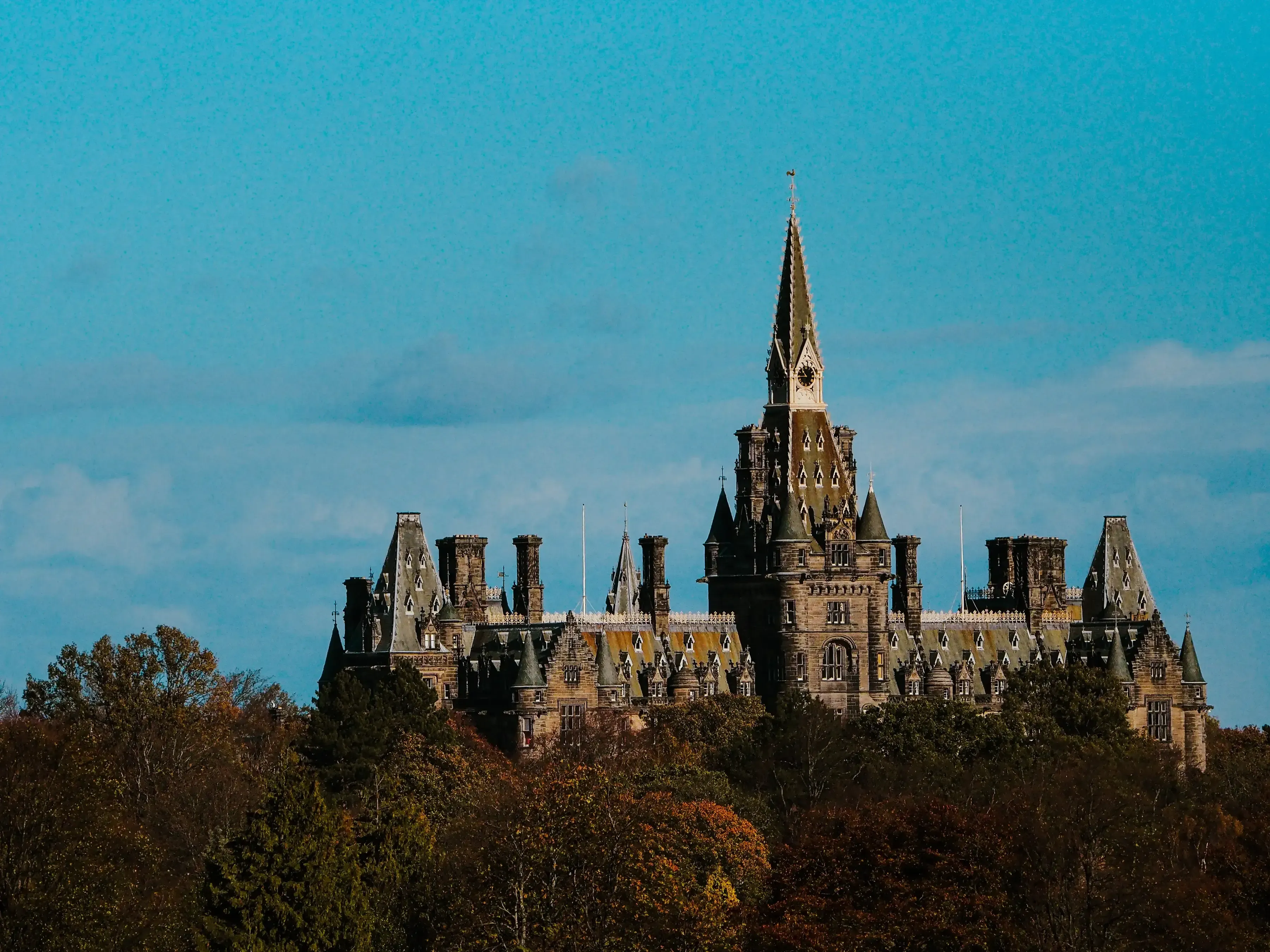 Close-up detail of the roof, towers, and battlements of a historic stone castle