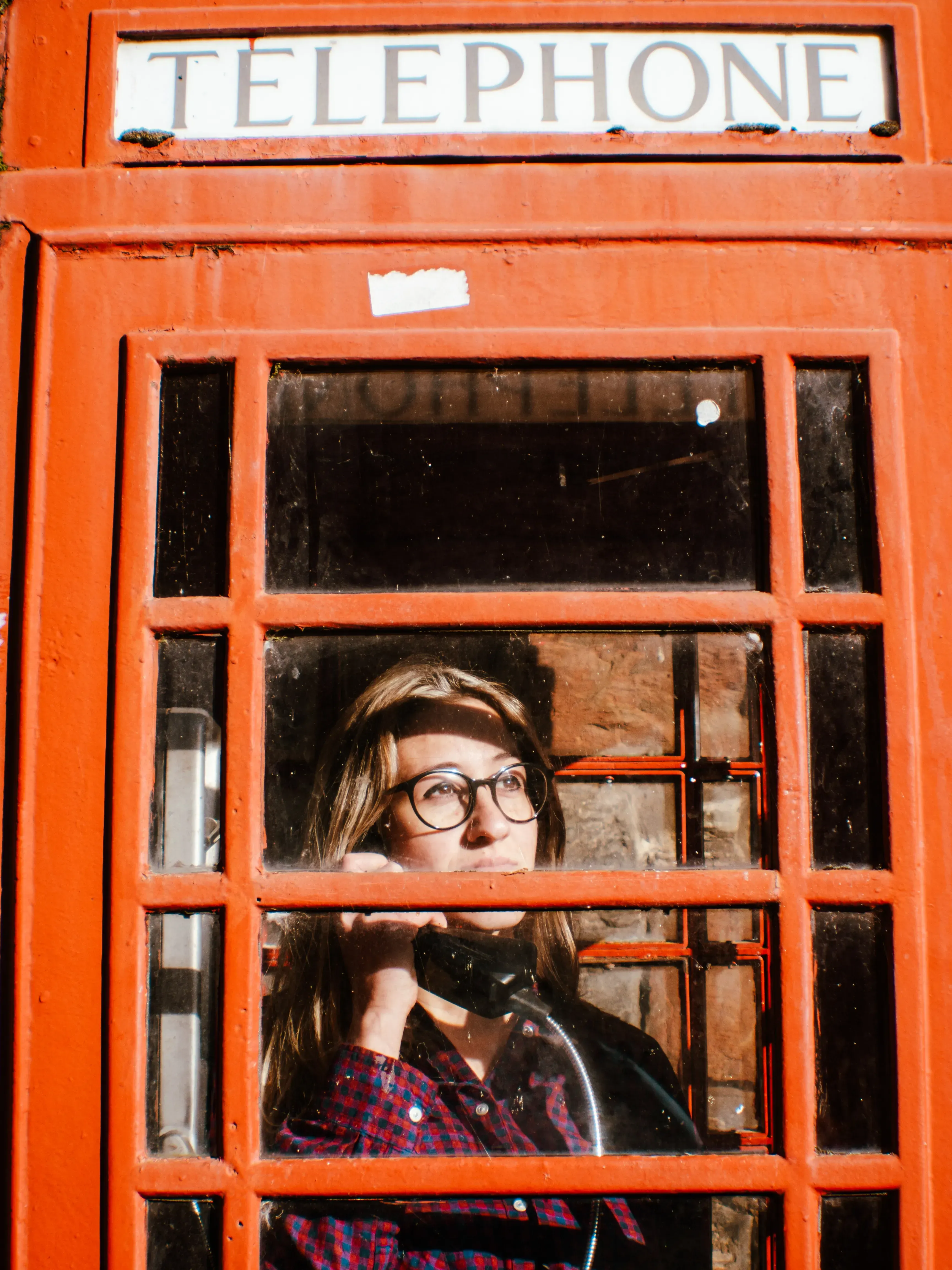 Letizia posing inside a traditional bright red British telephone box.