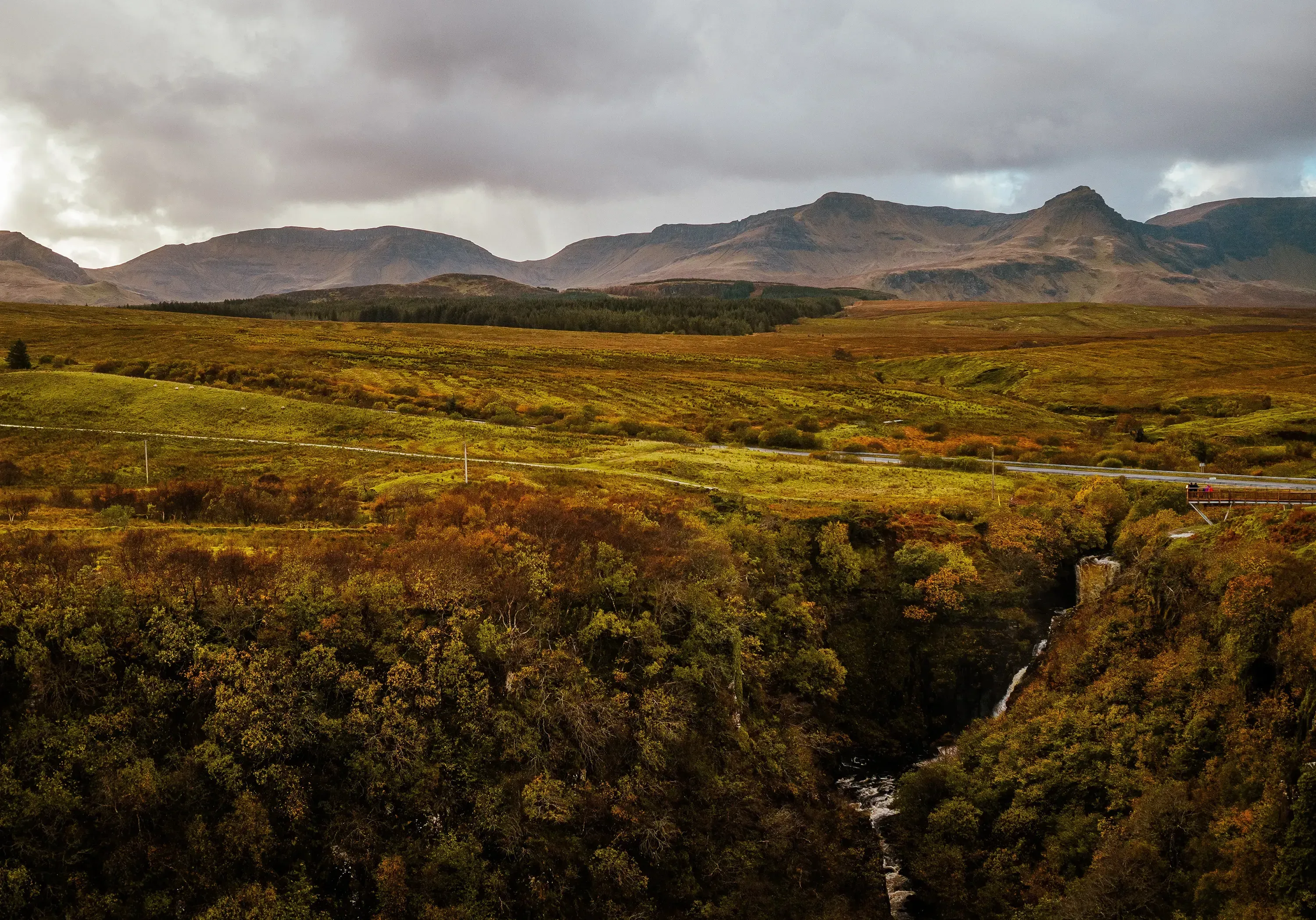 Vast, misty green moorland and undulating hills of the Scottish Highlands.