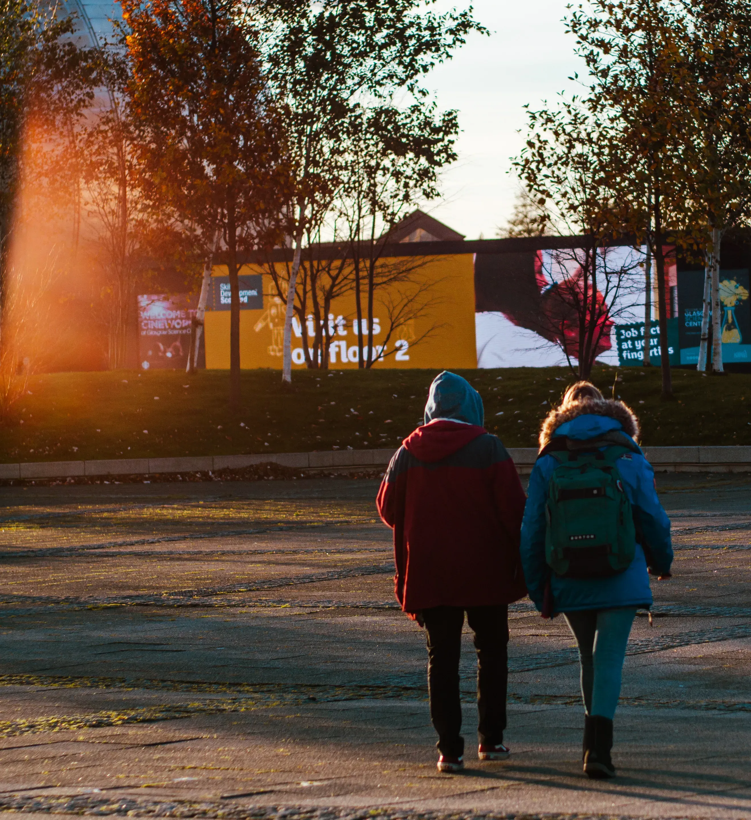 Person and Letizia walking with a bright sun flare (sun blur) creating a soft effect.