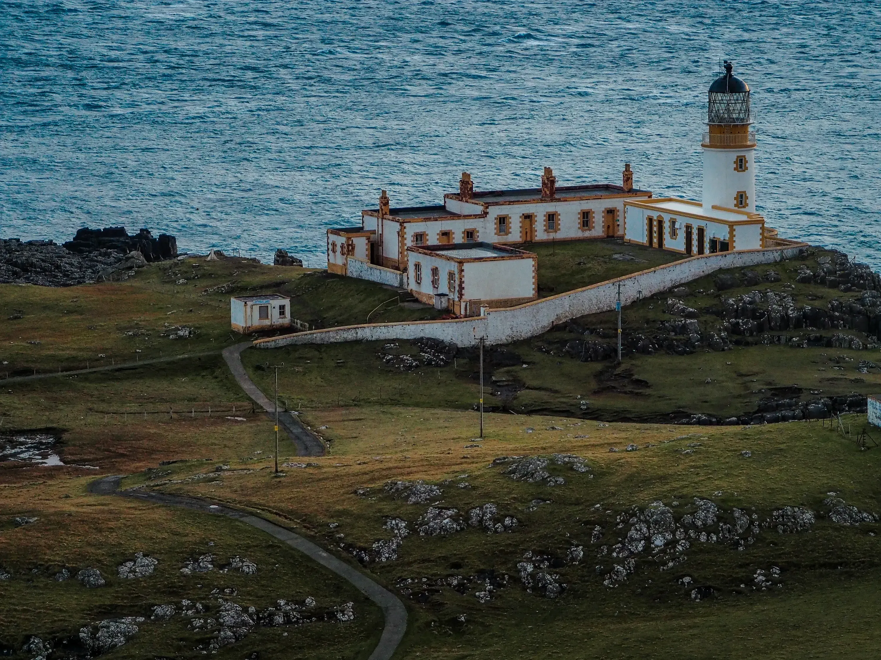 The picturesque Neist Point Lighthouse standing on a rocky cliff edge on the Isle of Skye.
