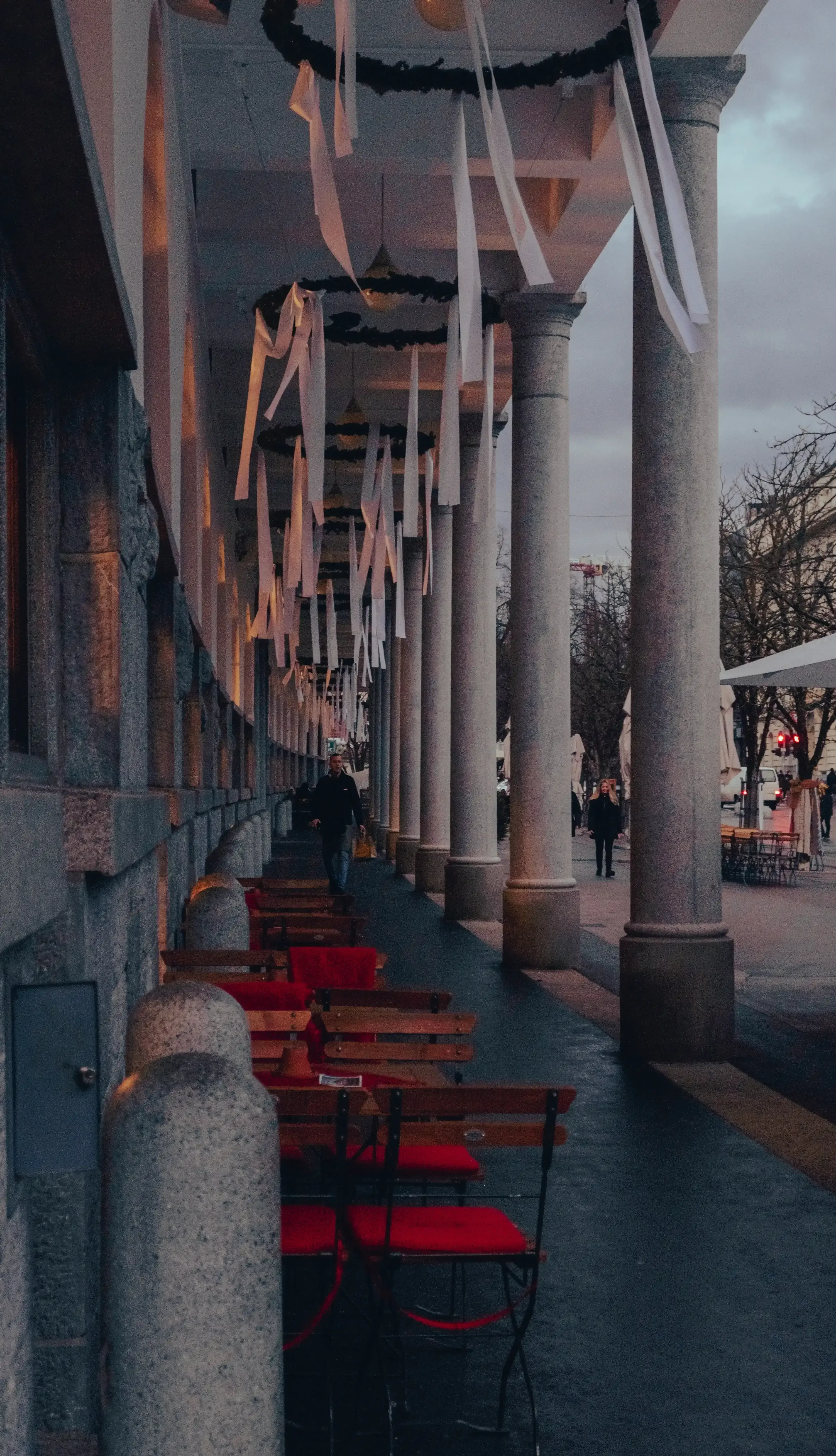 A narrow, pedestrianized street in the historic center of Ljubljana, lined with cafes and buildings.
