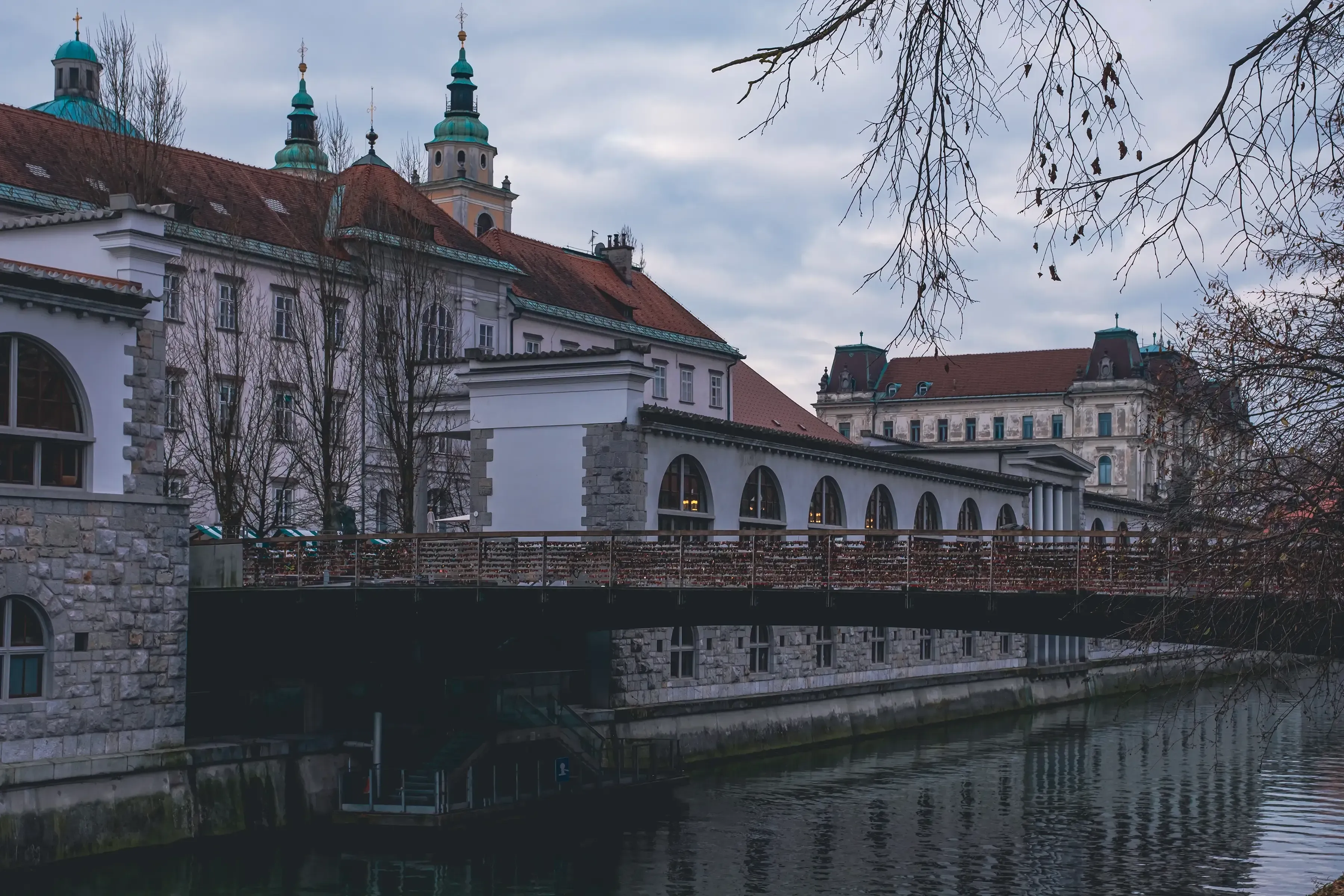 The Ljubljanica River flowing through the center of Ljubljana, flanked by bridges and cobblestone embankments.