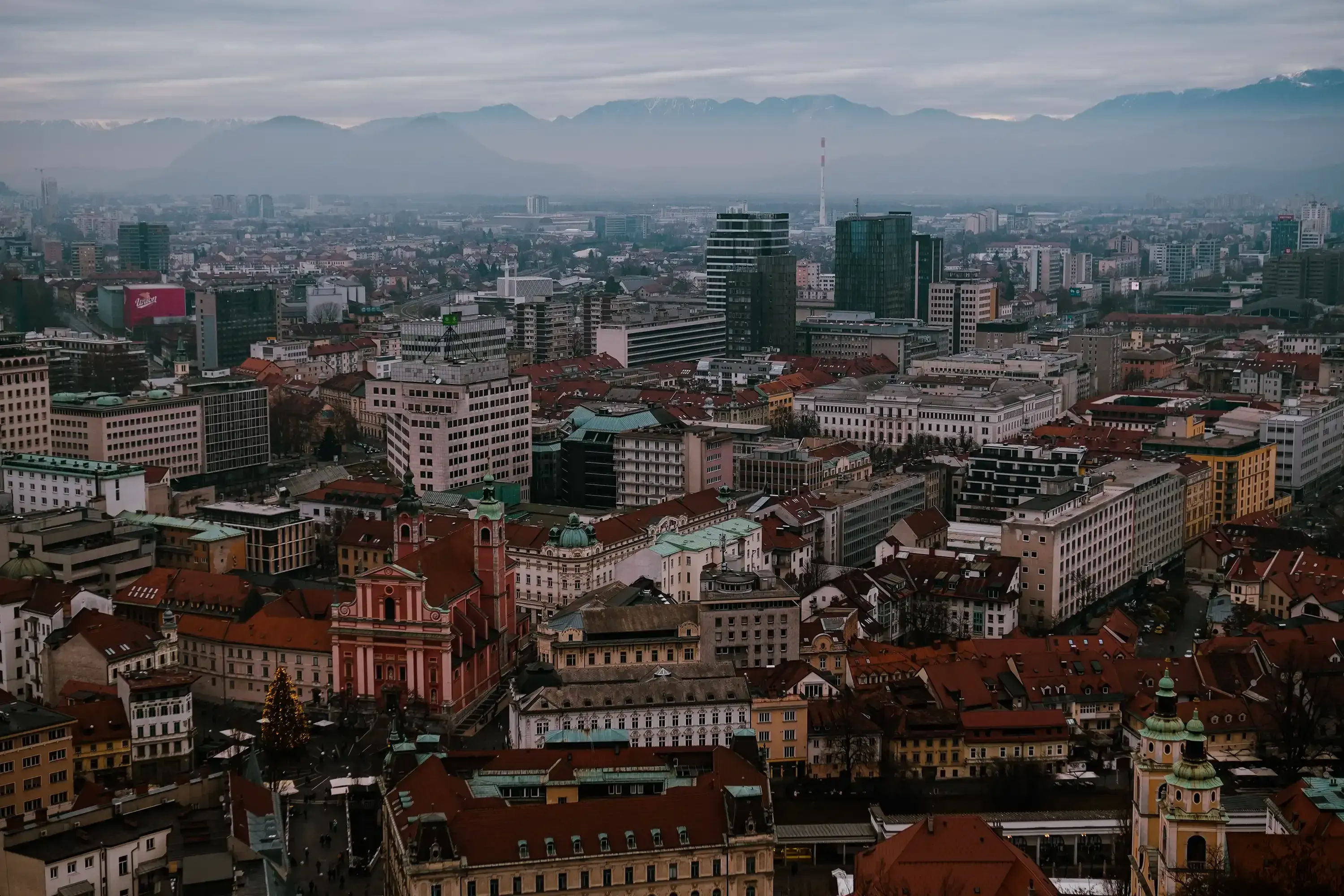 A panoramic aerial or high-vantage view showing the rooftops and city layout of Ljubljana.