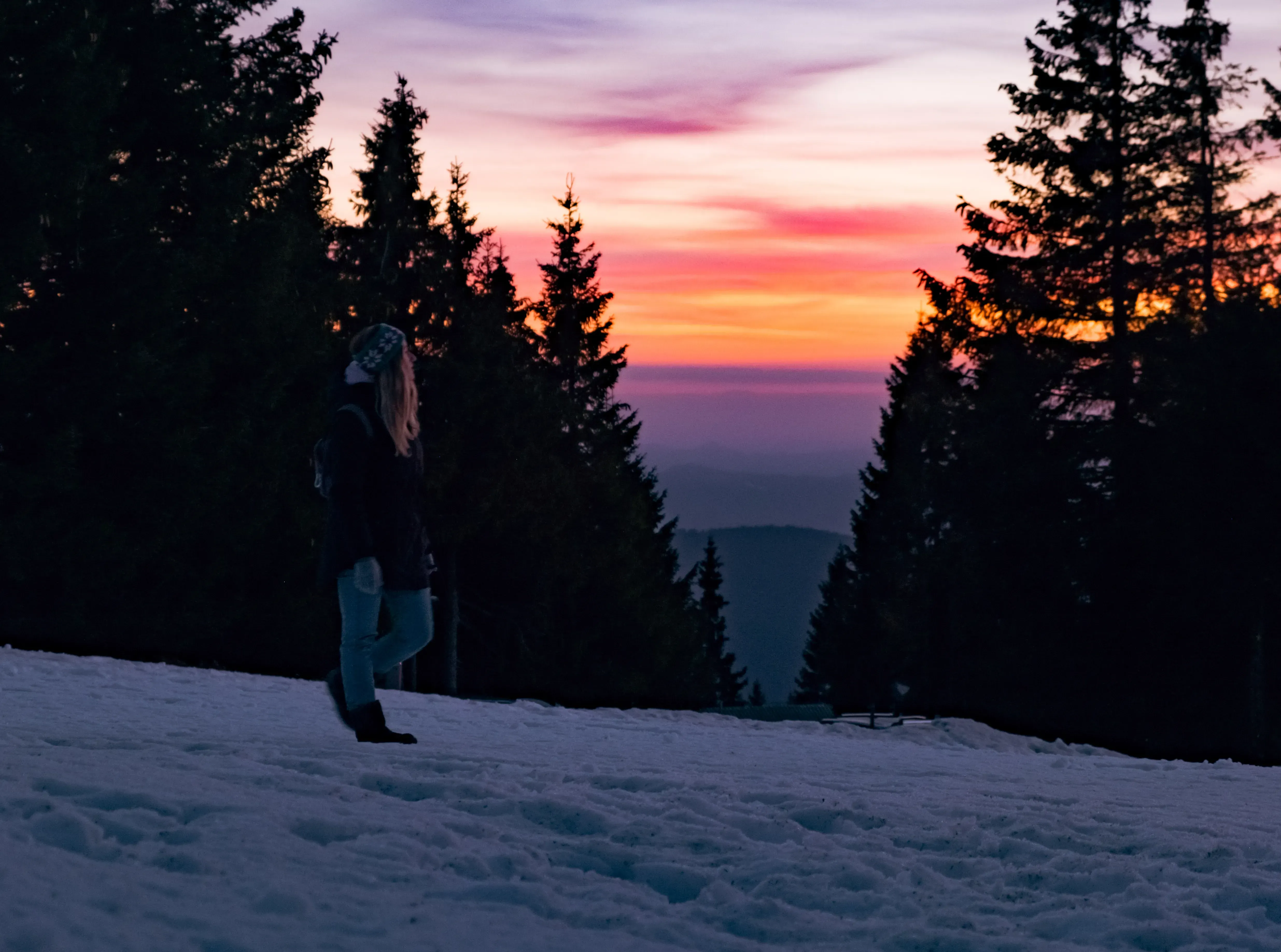 Letizia standing in the mountain landscape near Rogla, silhouetted against the bright colors of the sunset.