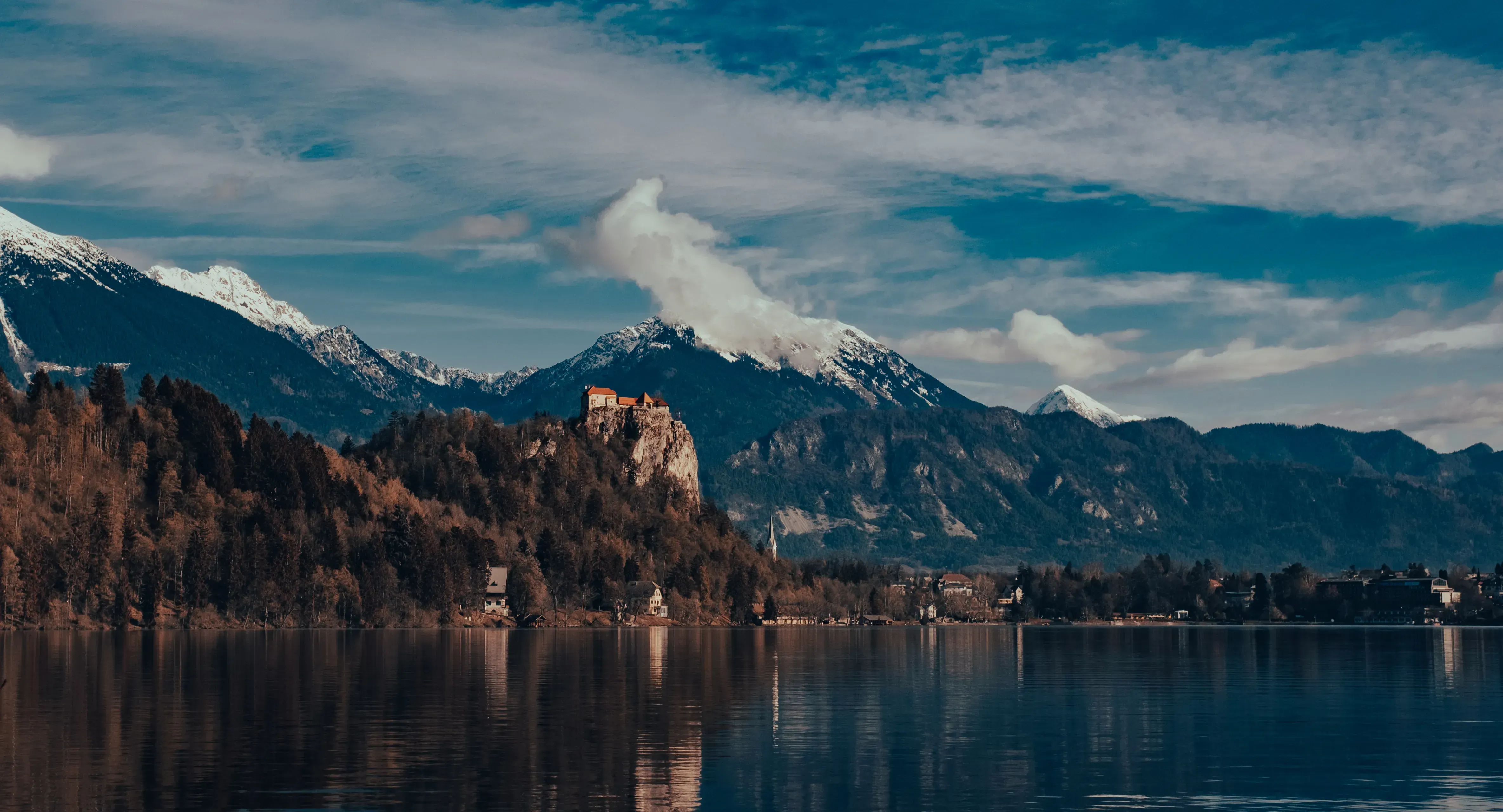 The medieval Bled Castle situated dramatically on a cliff overlooking Lake Bled and the island church.