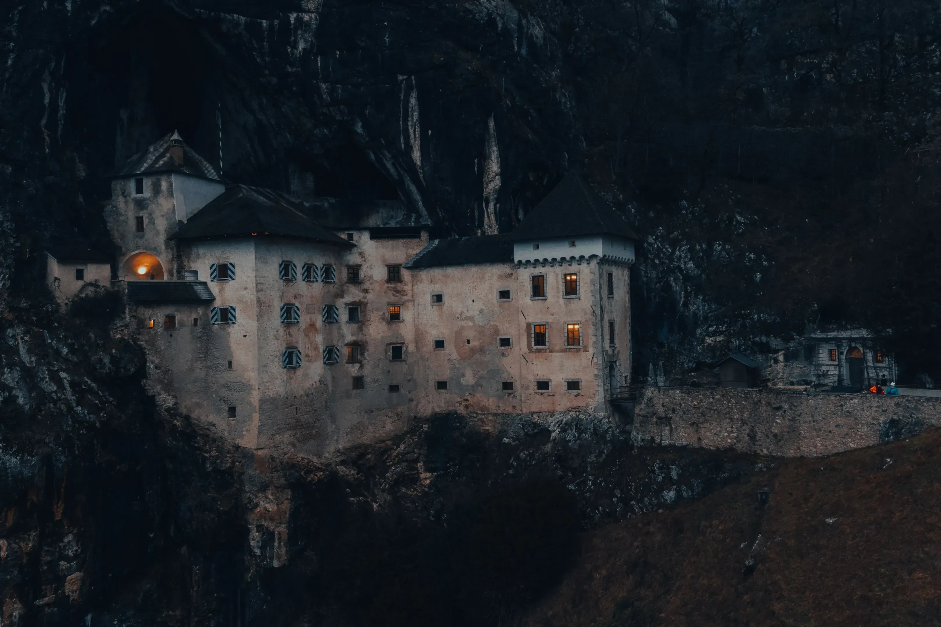 The dramatic medieval Predjama Castle built directly into the entrance of a vertical cave wall at night