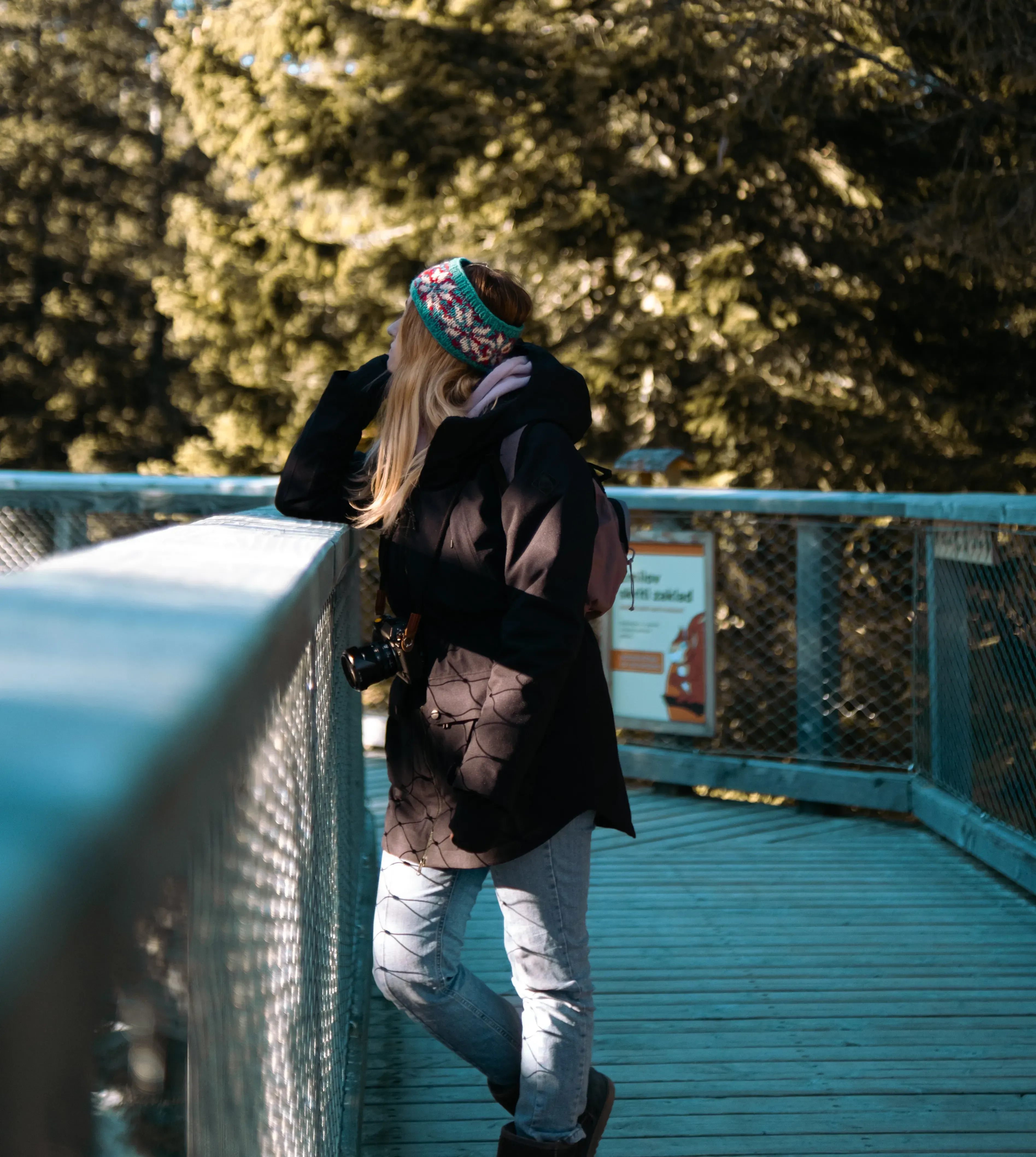 Letizia standing on the wooden treetop walkway, looking out over the expansive forest canopy below.