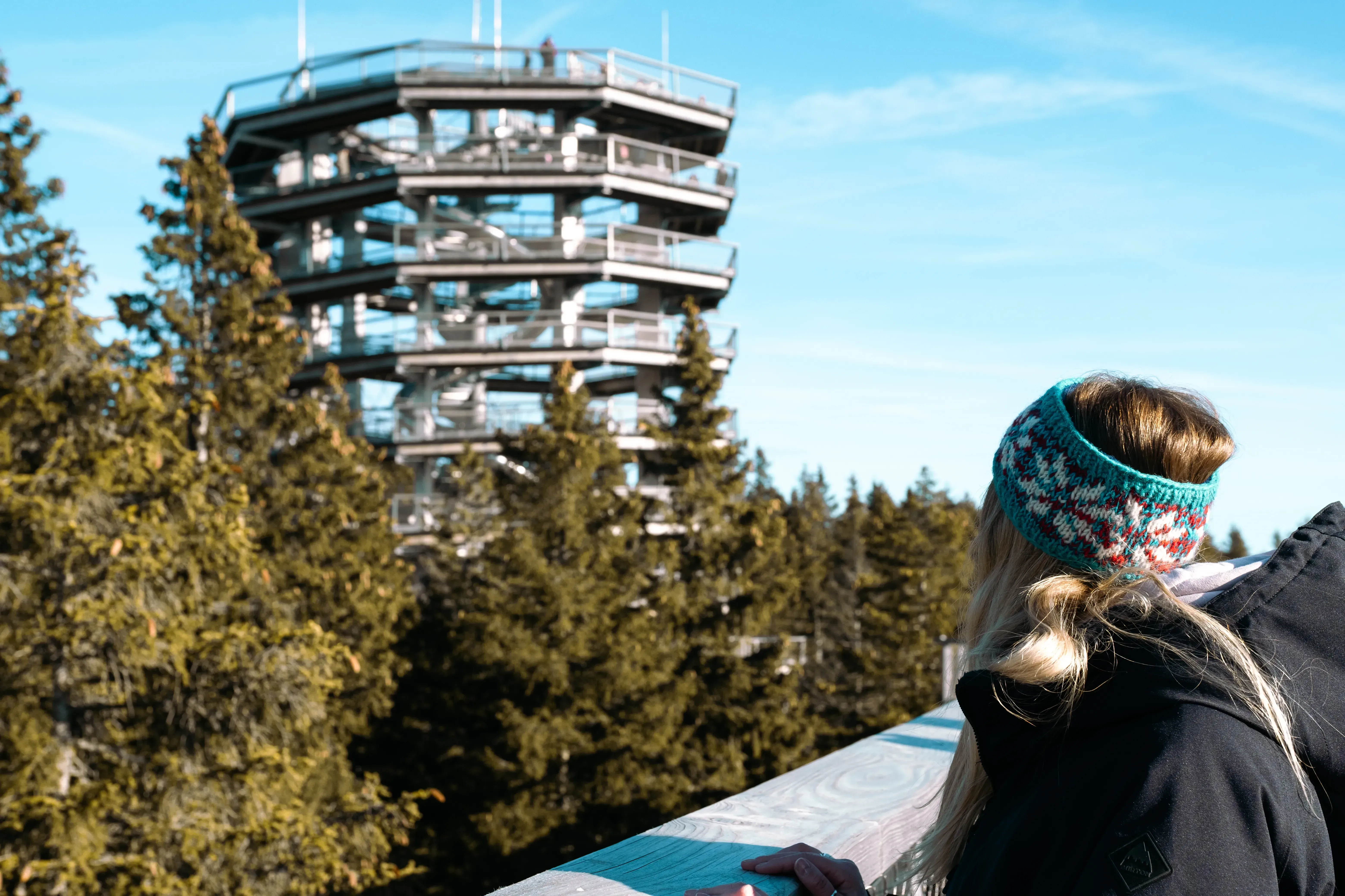 Letizia observing the long, enclosed spiral slide attached to the treetop walking path at Rogla.