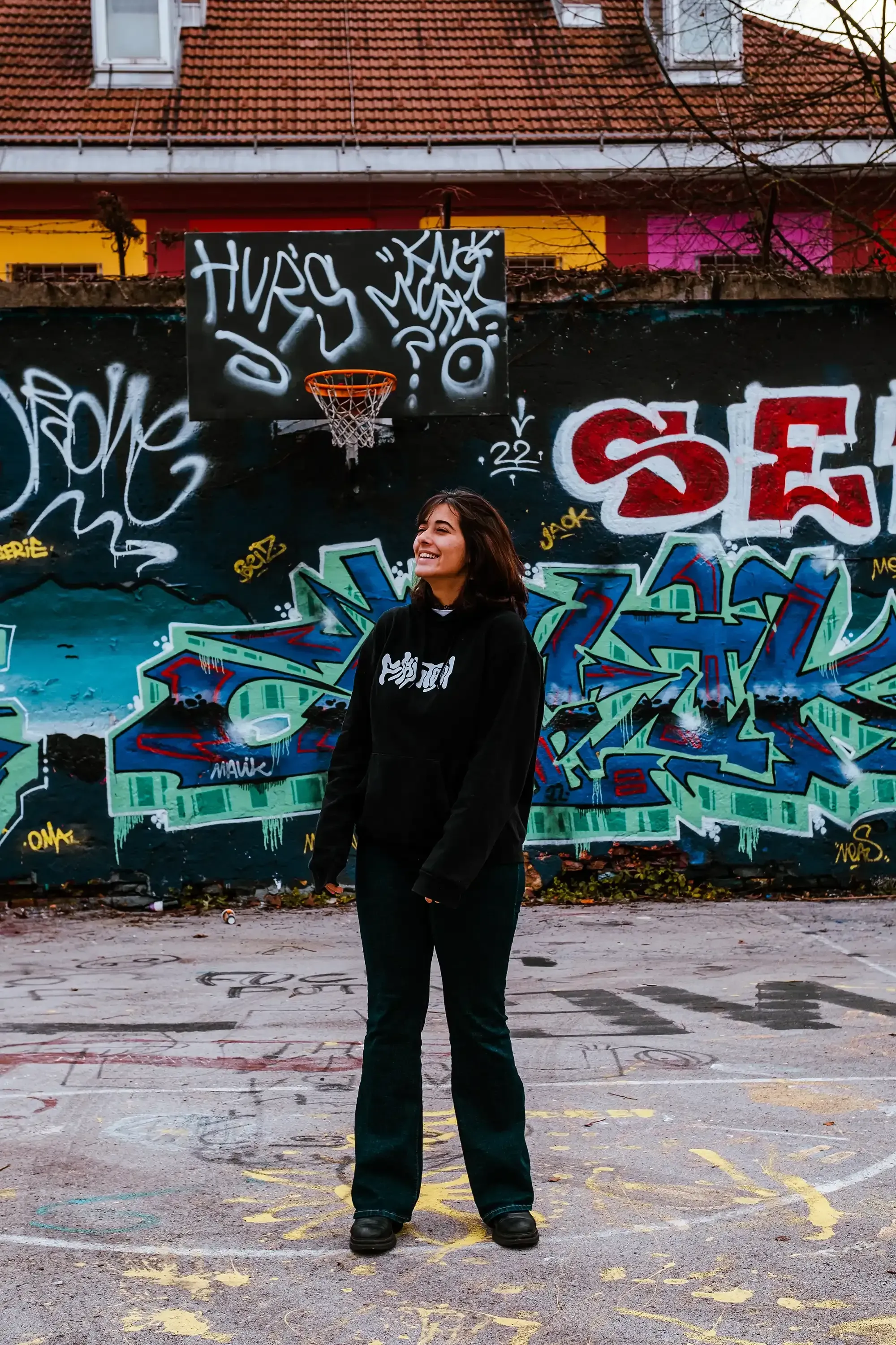 Paulina posing in front of a section of the unique street art and sculptures characteristic of Metelkova Mesto.