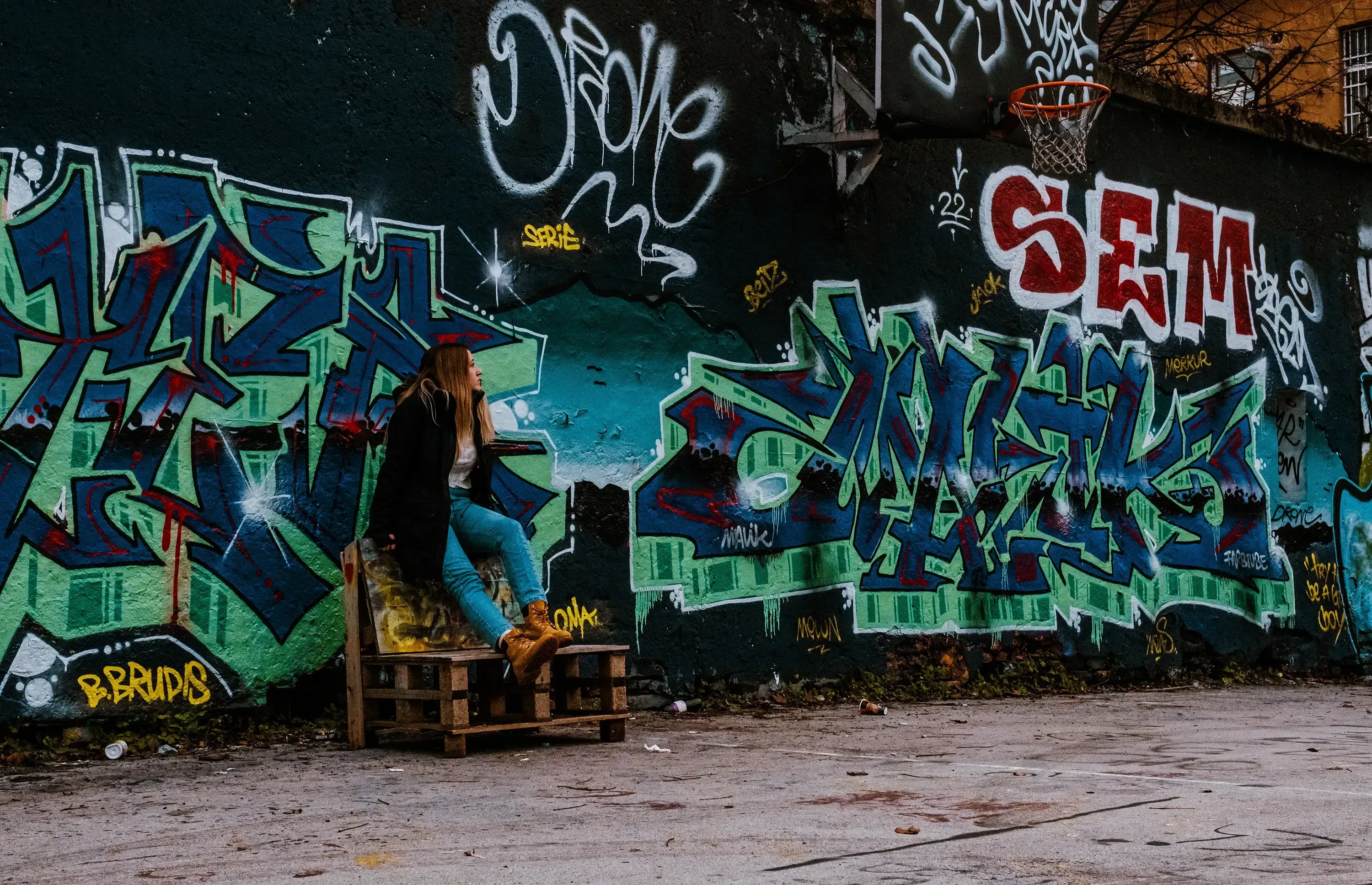 Letizia sitting on a wooden pallet in the arts and culture district of Metelkova Mesto, Ljubljana.