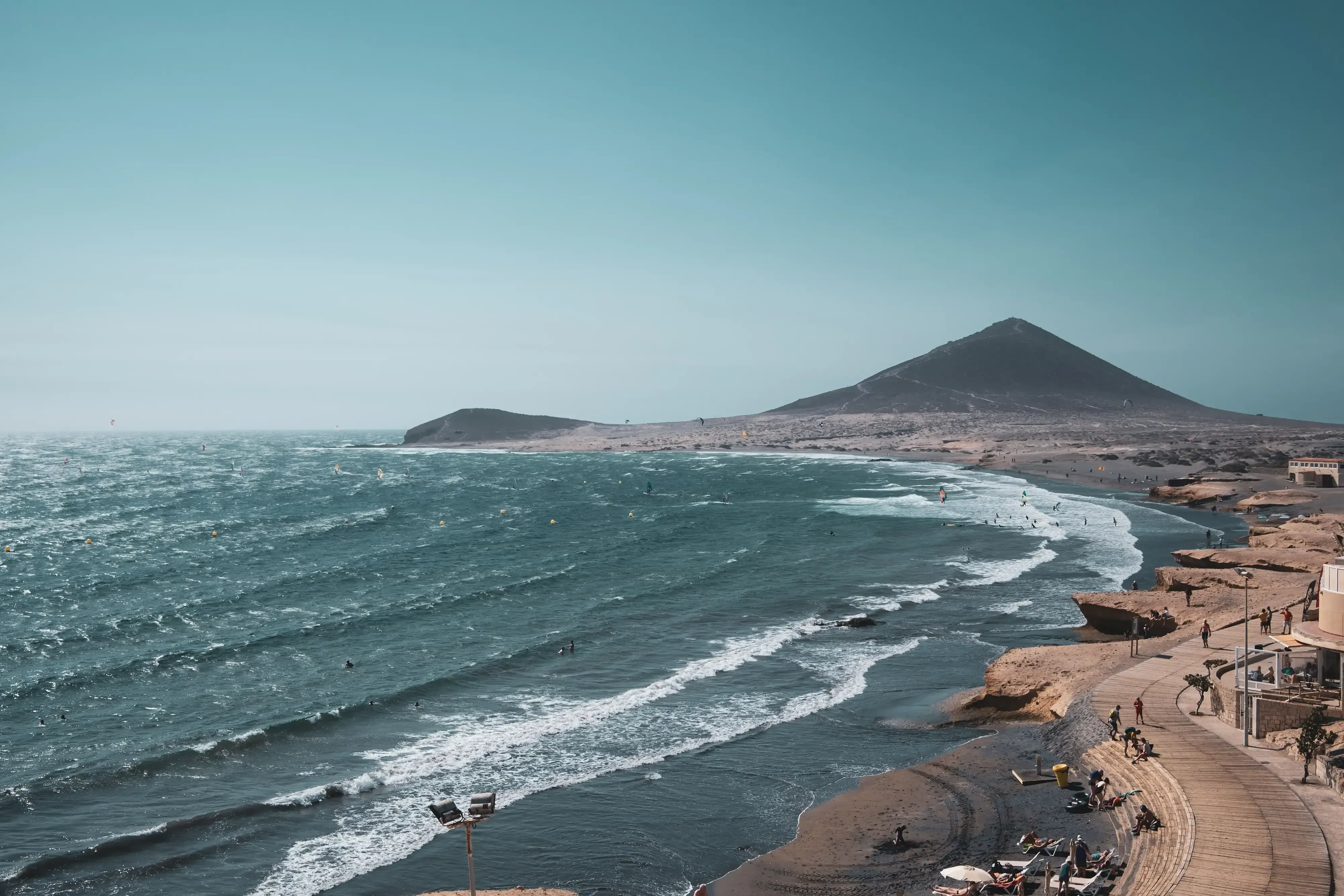 The famous black sand beach of Tenerife (e.g., Playa del Socorro), popular for its large waves and surfing activity.