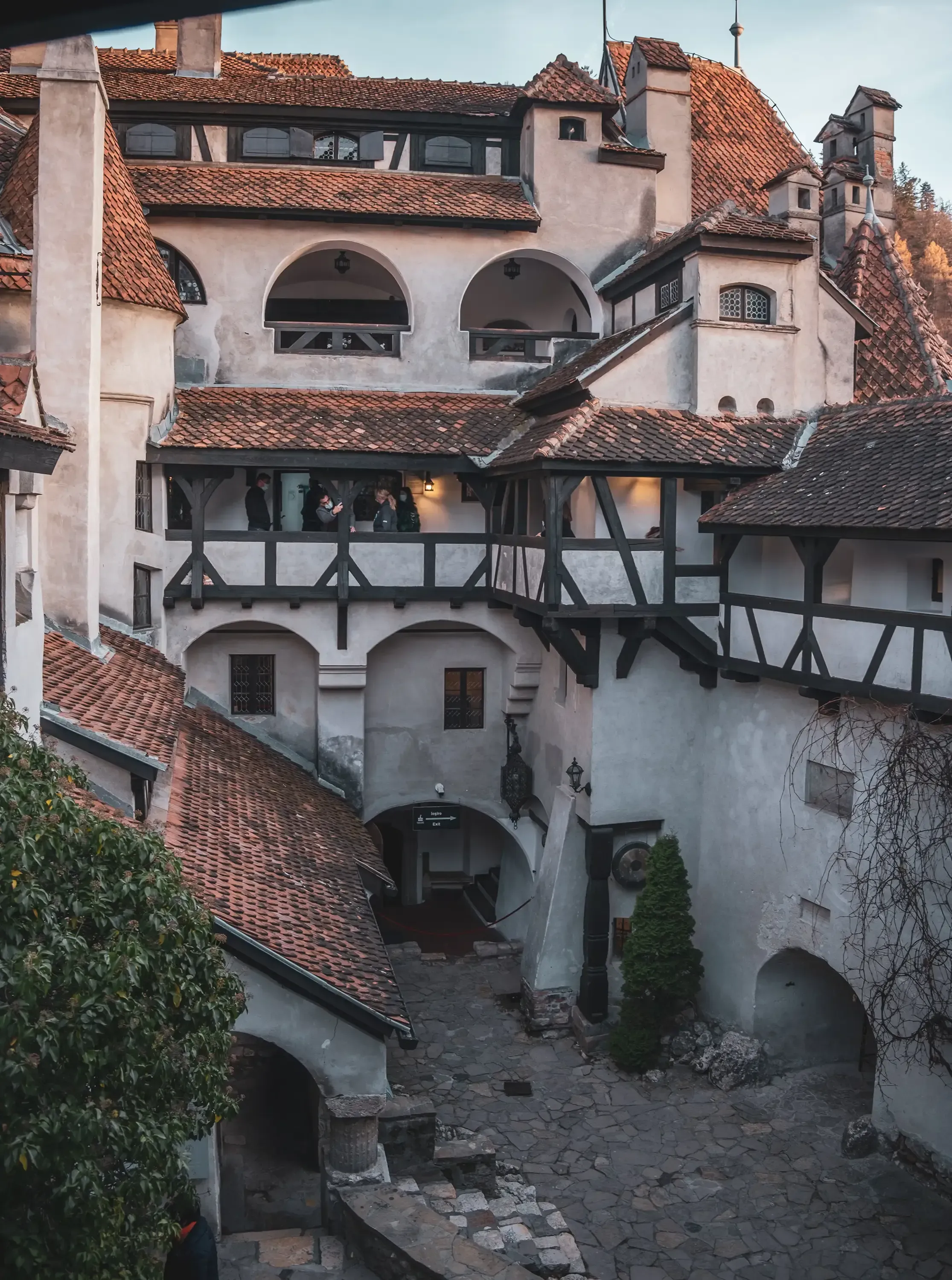 The inner medieval courtyard of Bran Castle (Dracula's Castle) with its towers and surrounding pathways.