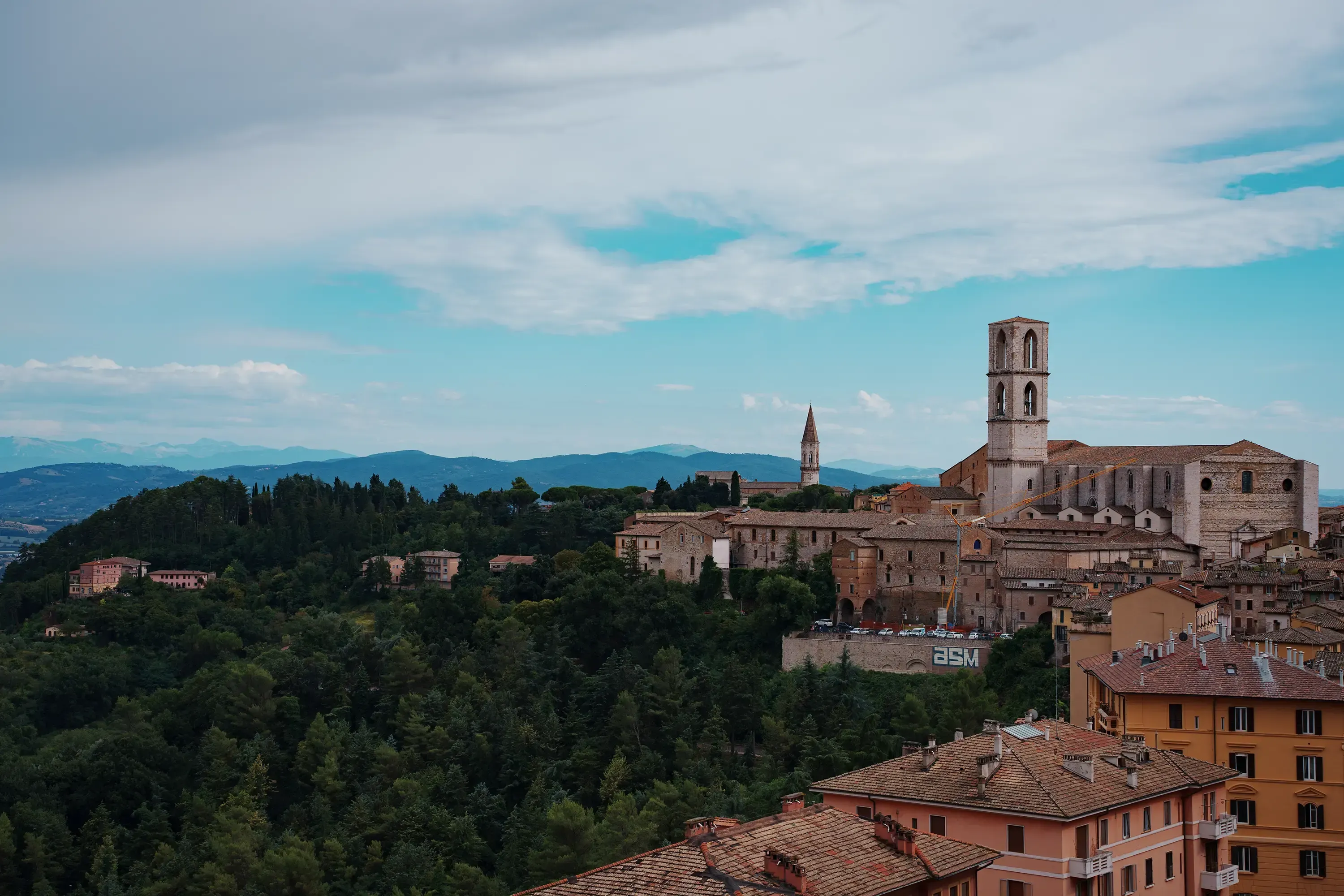 Wide view of the rooftops and hillsides of the city of Perugia.