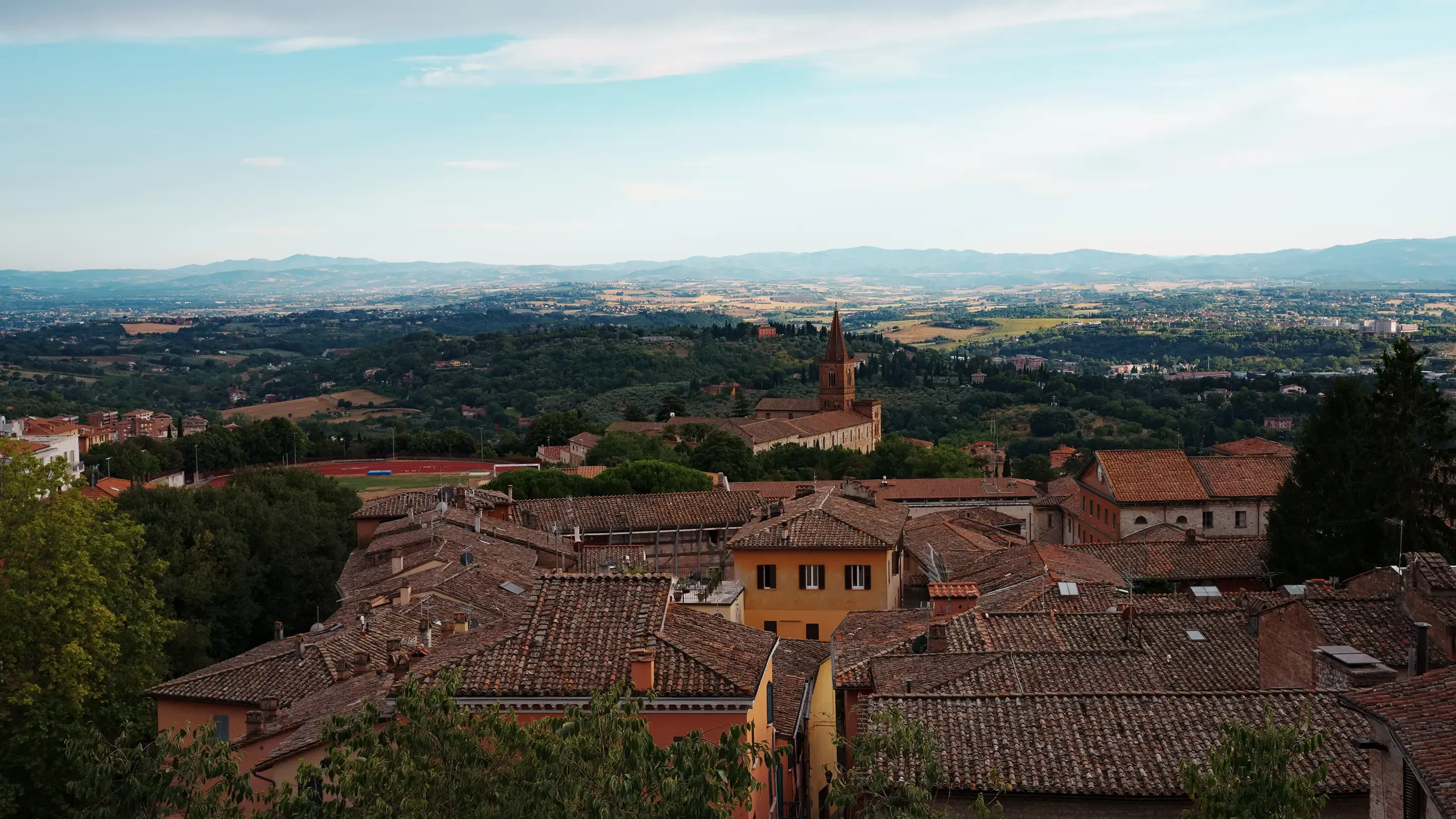 Expansive scenic overlook of the Italian city of Perugia and the surrounding valleys.